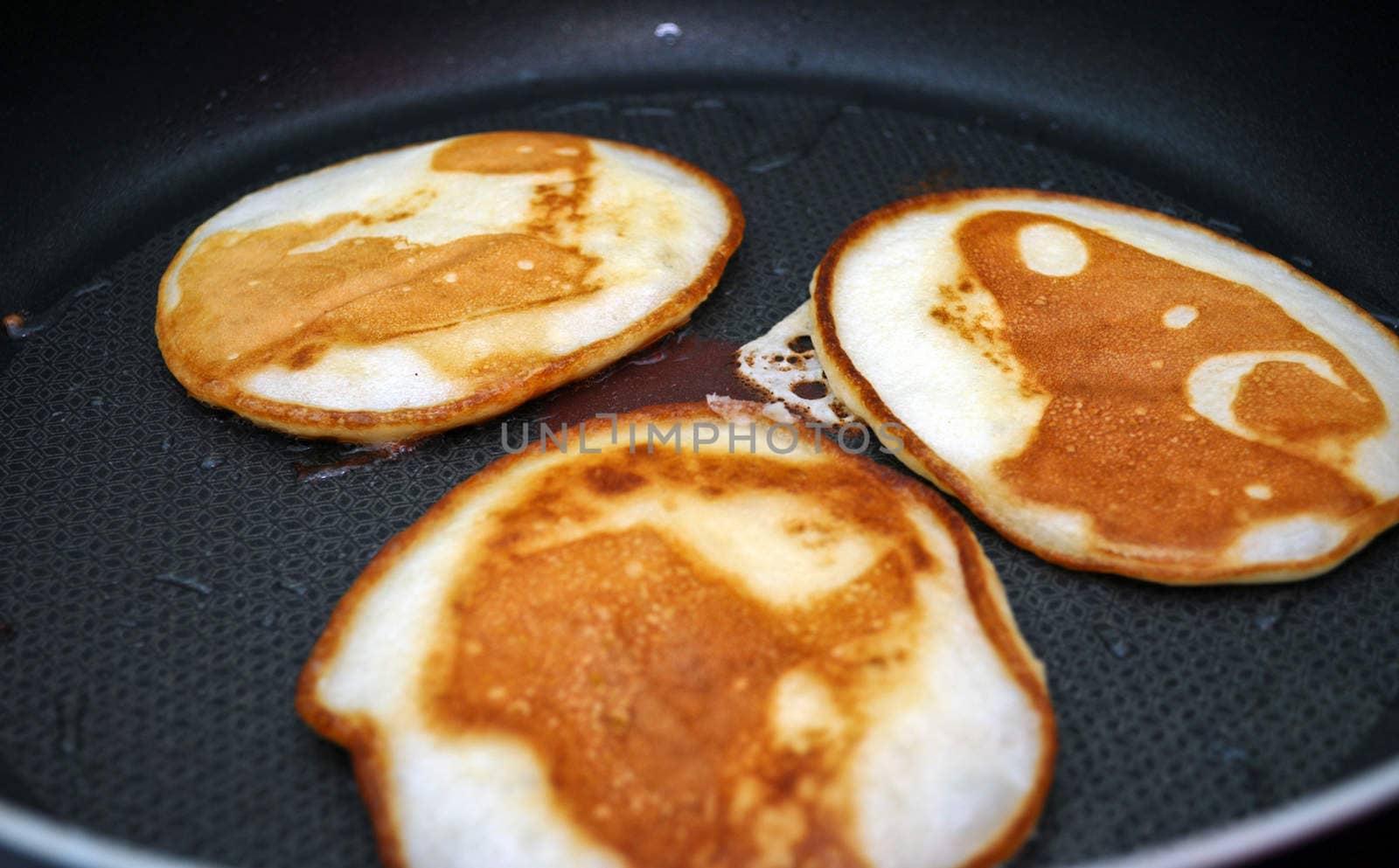Fritters on a frying pan pancakes on the griddle