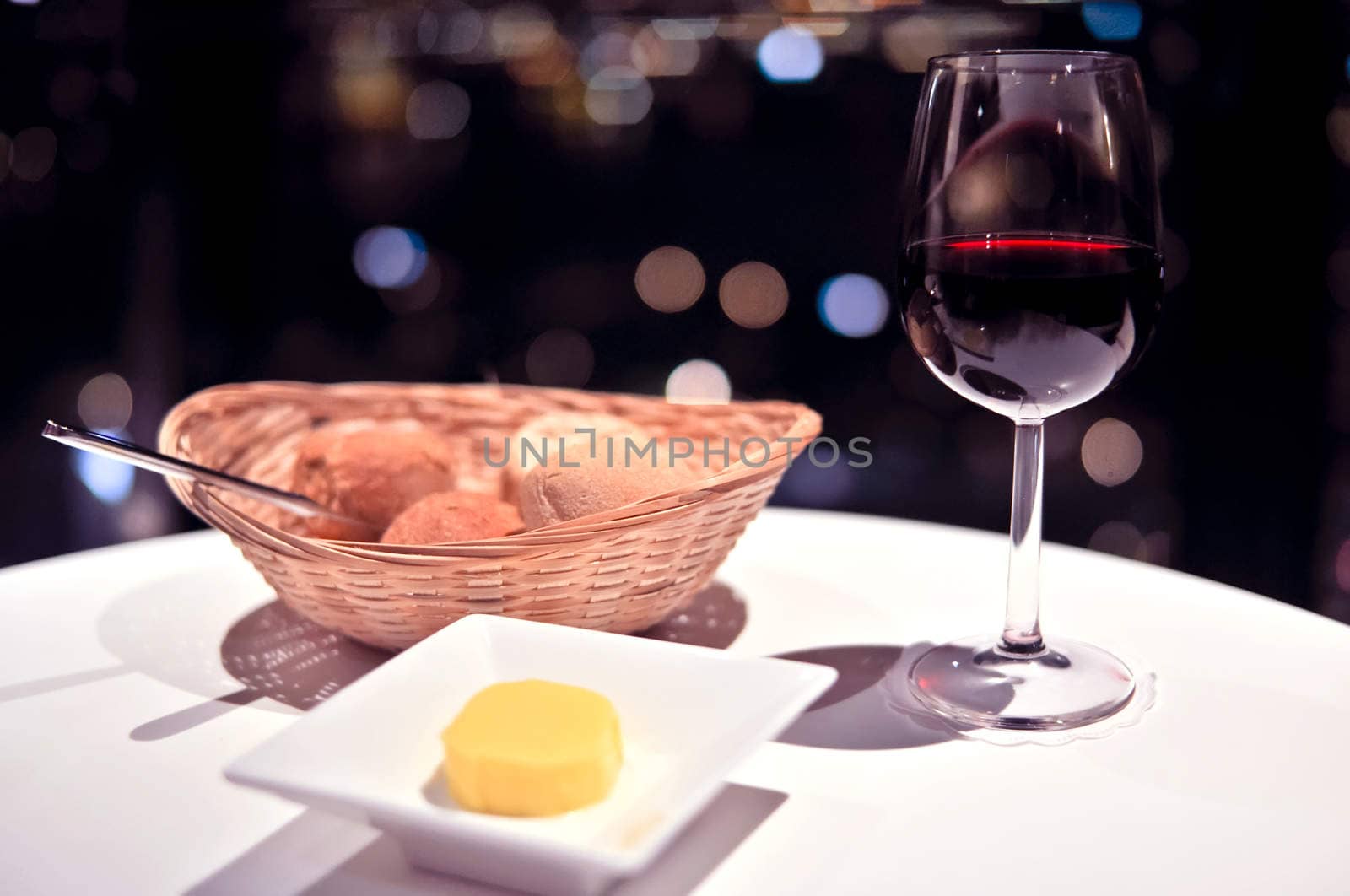 glass of red wine on background night city lights by vlaru