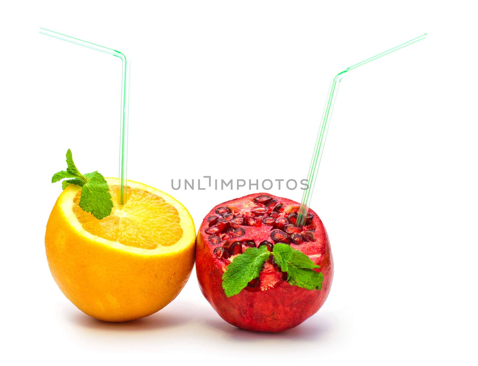 orange and pomegranate with a straw on a white background