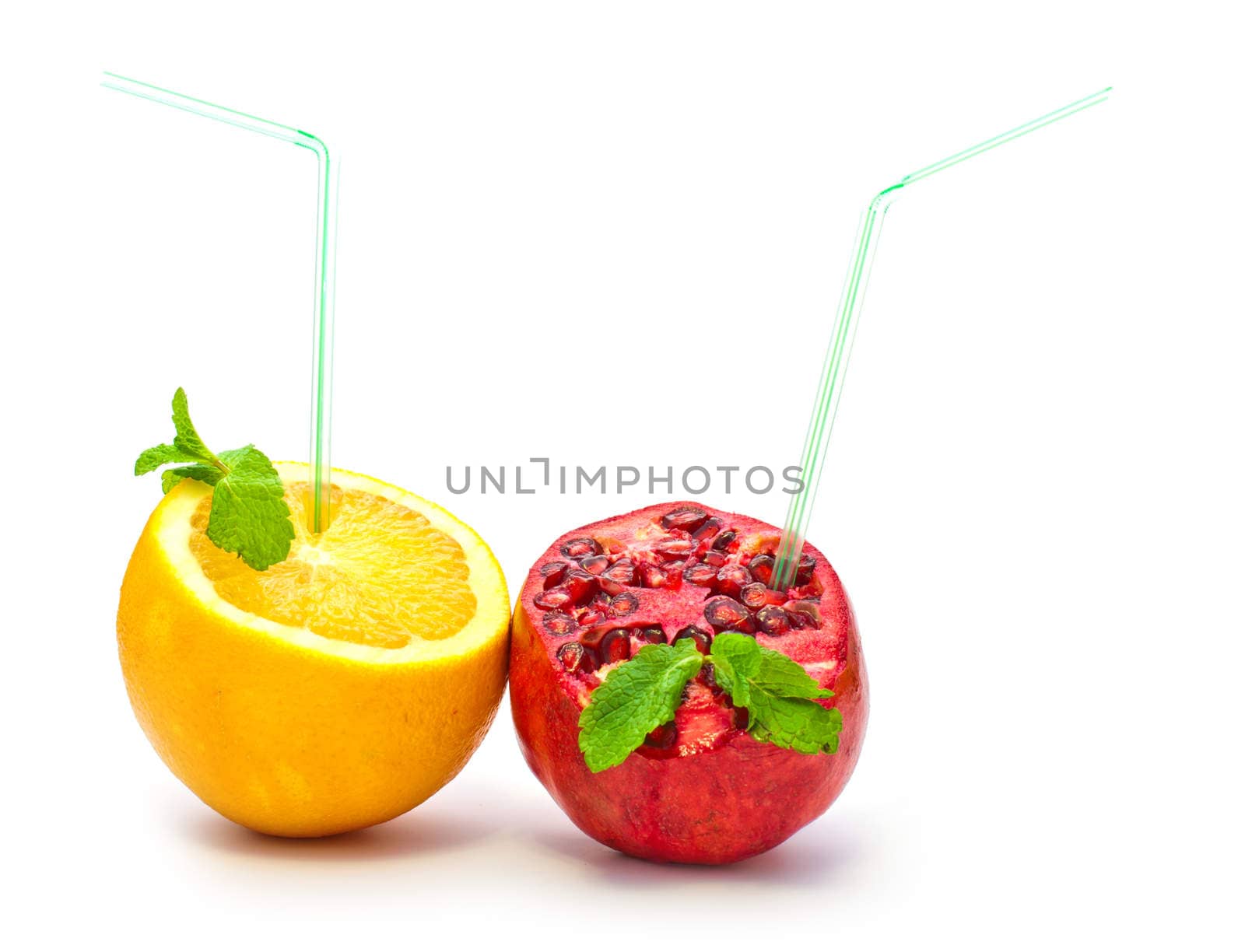 orange and pomegranate with a straw on a white background