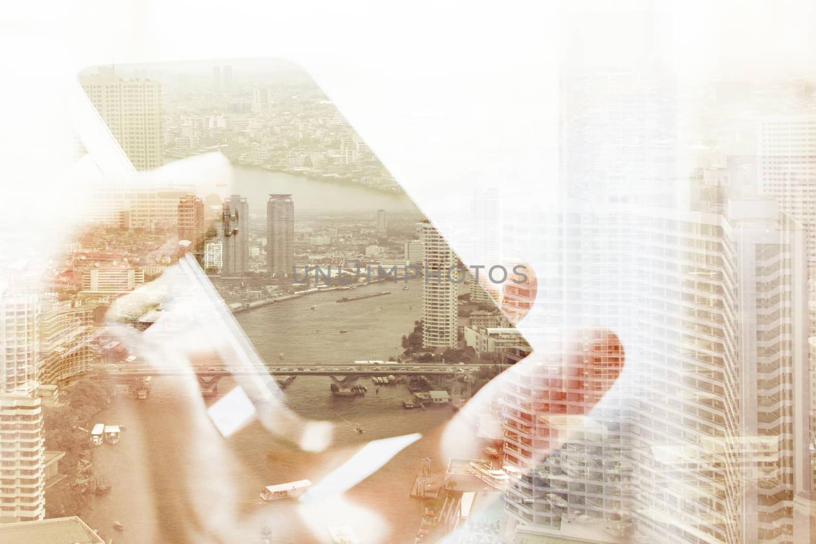 Double exposure of cityscape and smart phone, business technology concept.