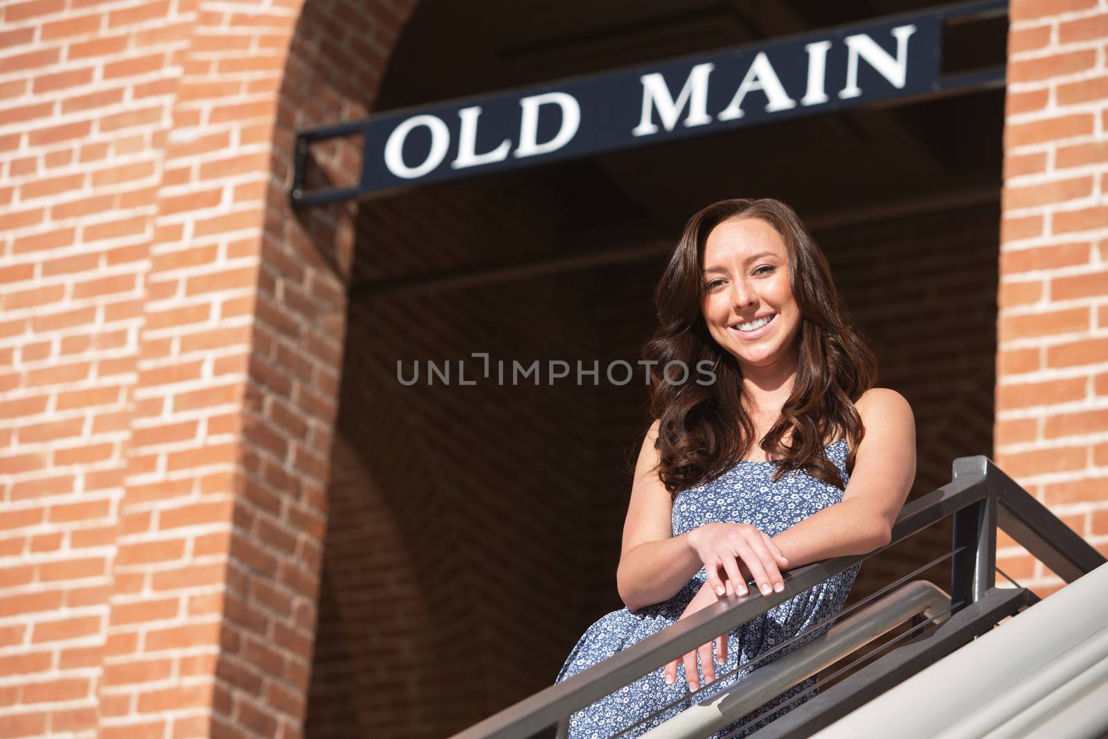 Smiling Caucasian female leaning on railing outdoors