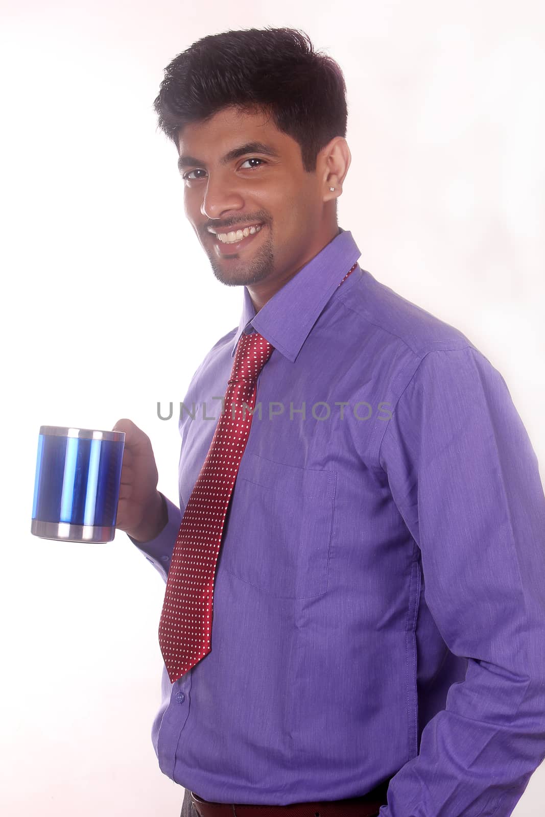 Attractive businessman drinking coffee in the office by ajithpride