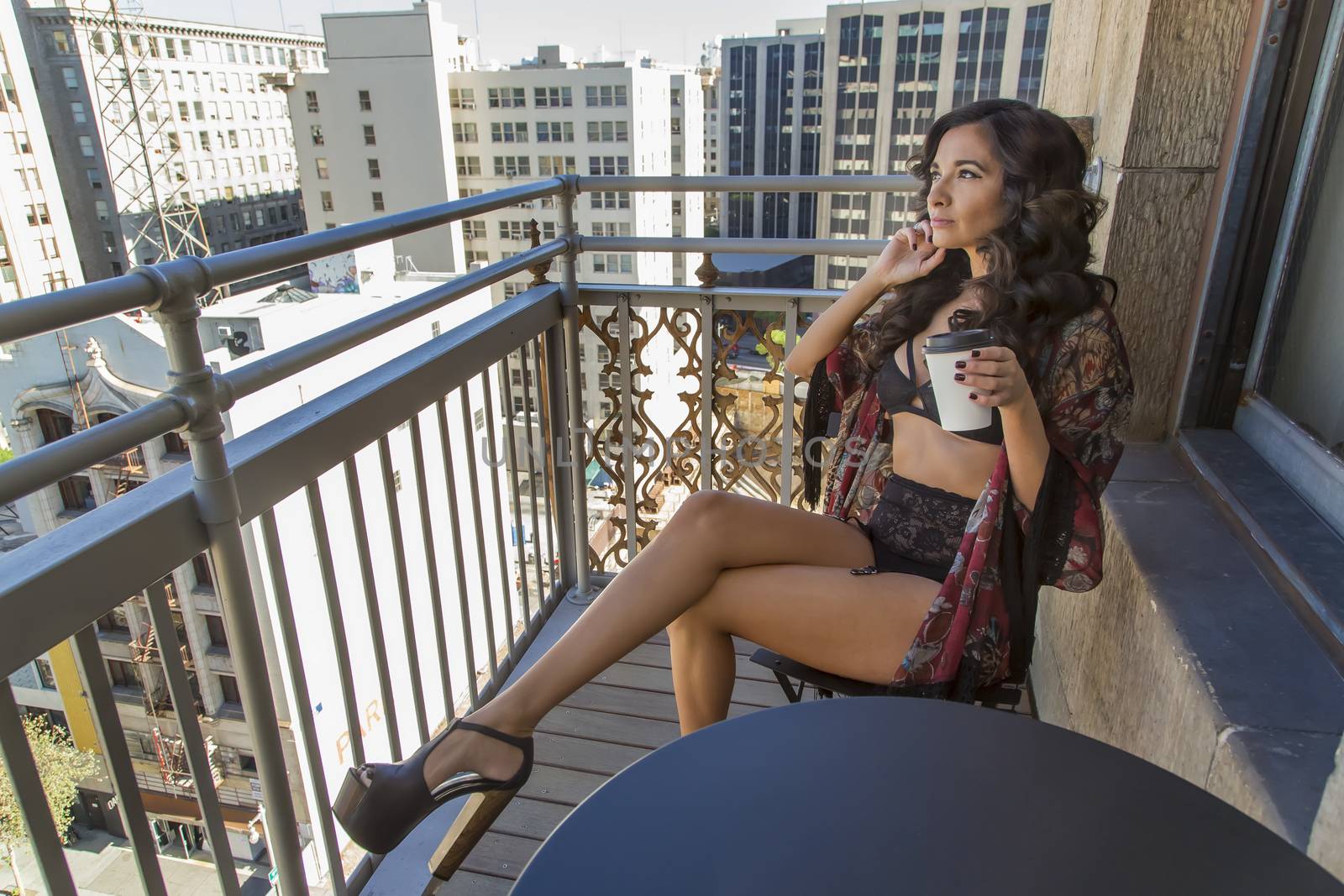 A brunette model on a balcony in a city environment