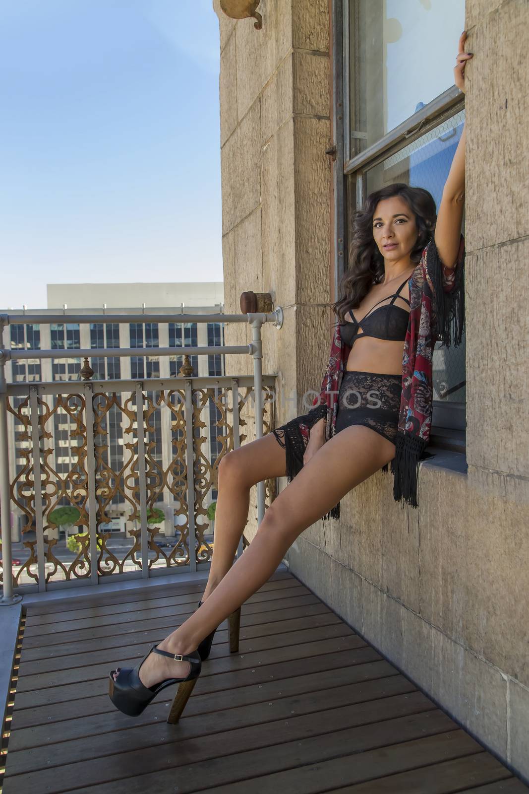 A brunette model on a balcony in a city environment