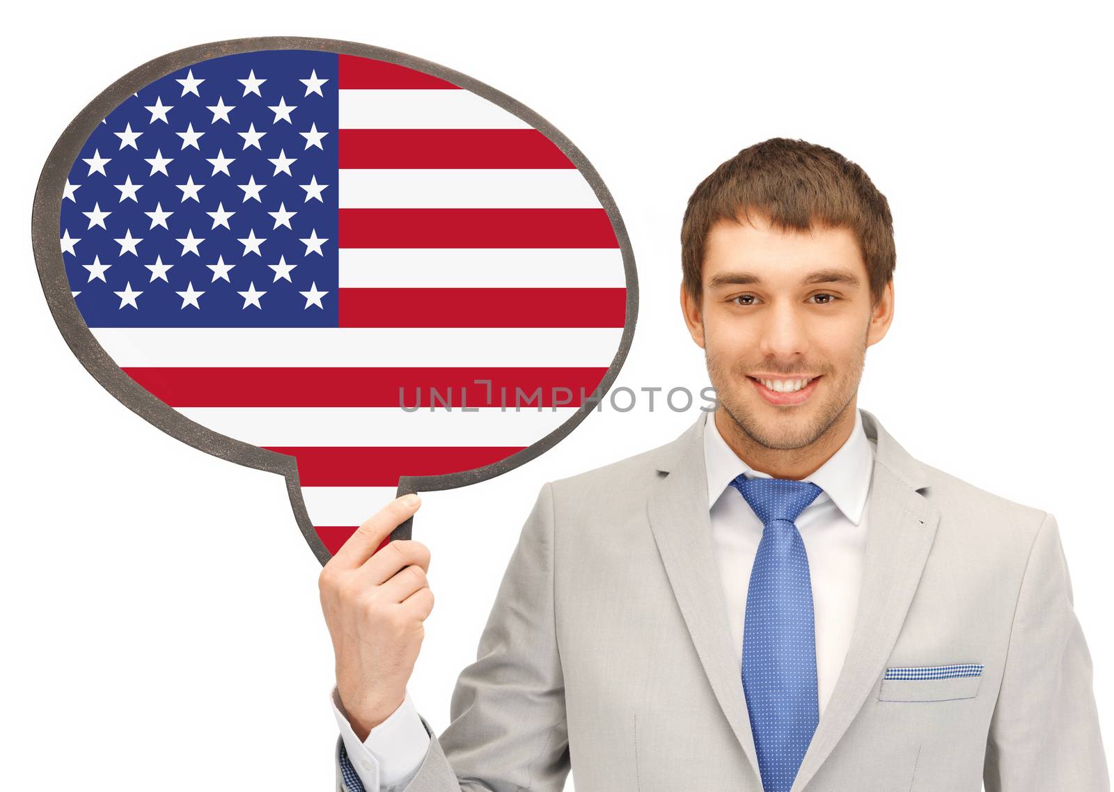 education, foreign language, english, people and communication concept - smiling young man or businessman in tie and suit holding text bubble of american flag