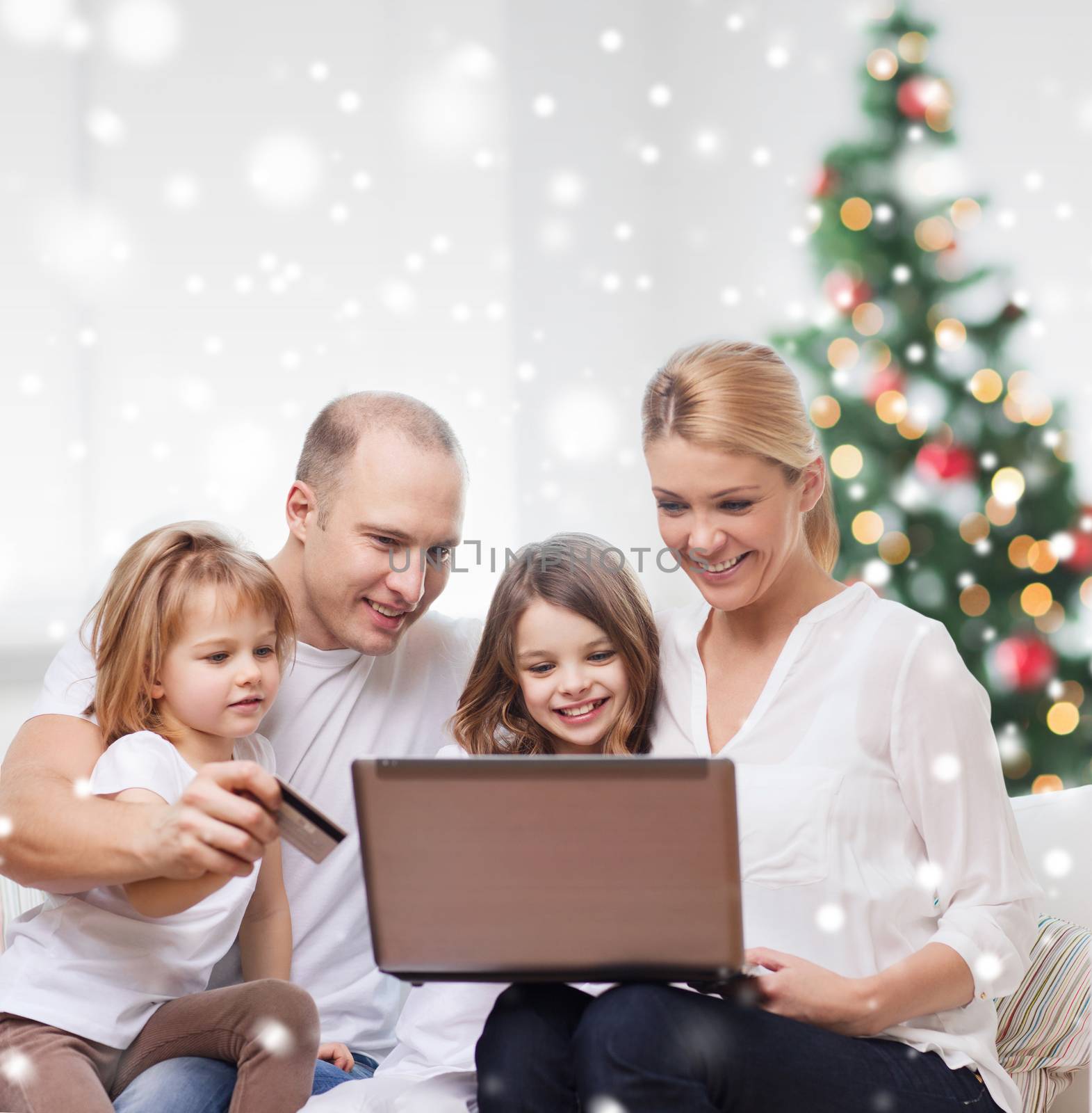 happy family with laptop and credit card at home by dolgachov