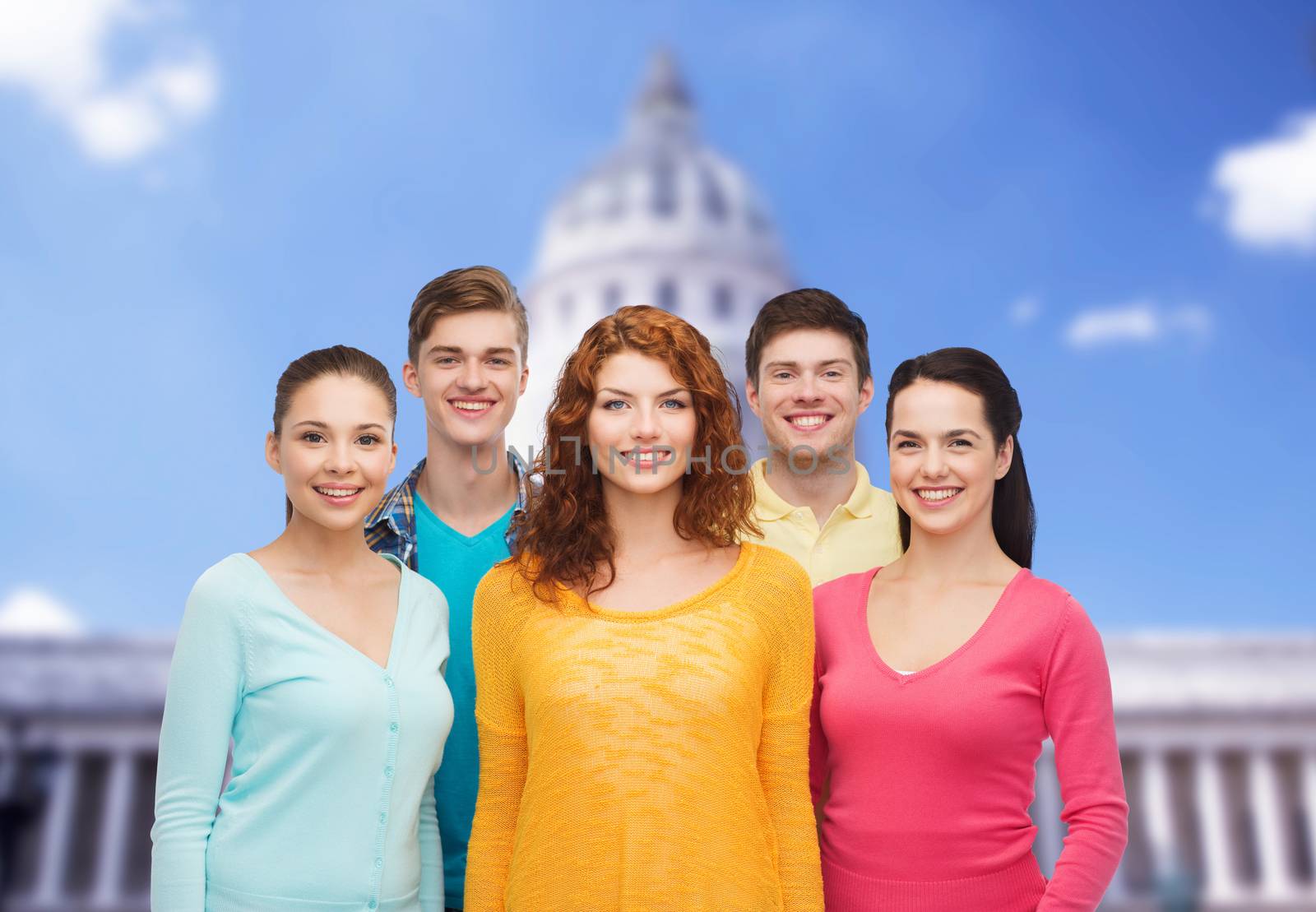 friendship, tourism, travel and people concept - group of smiling teenagers standing over white house background