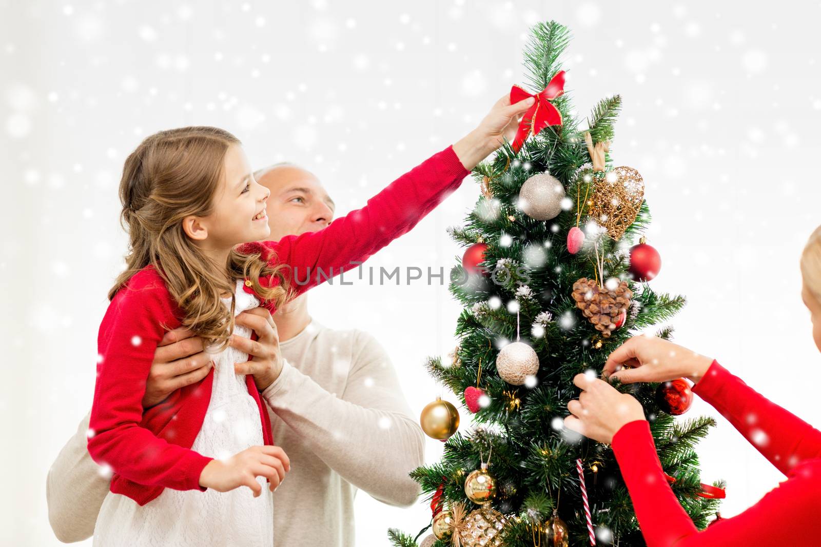 smiling family decorating christmas tree at home by dolgachov