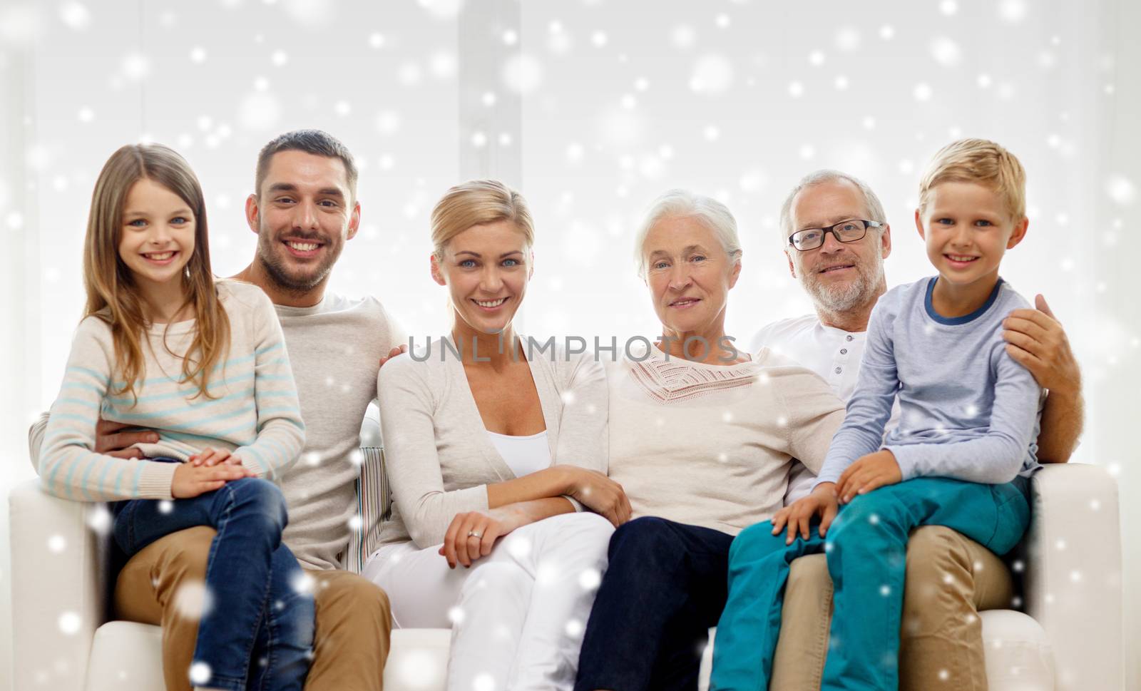 happy family sitting on couch at home by dolgachov