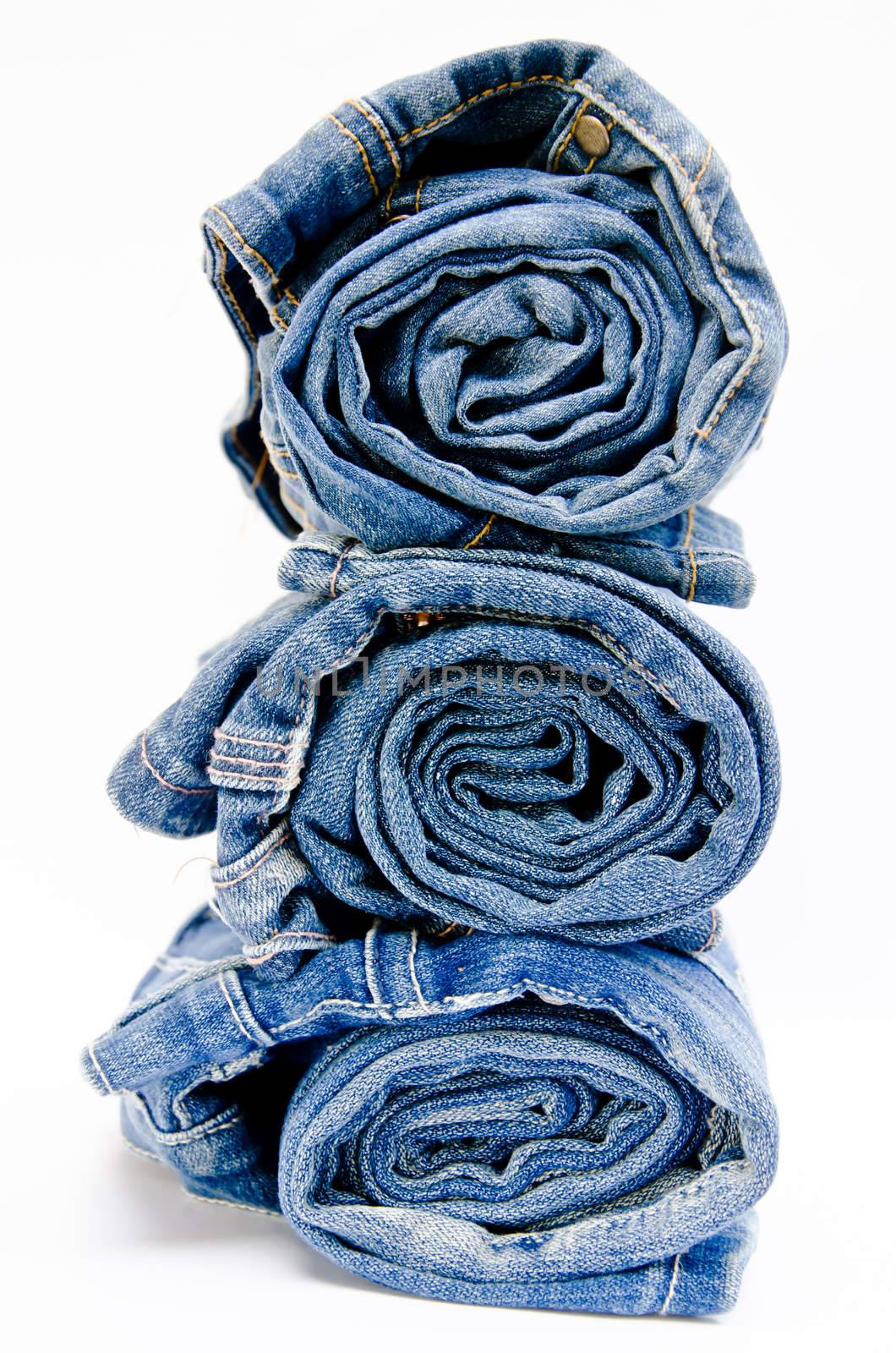 roll blue denim jeans arranged in stack by Gamjai