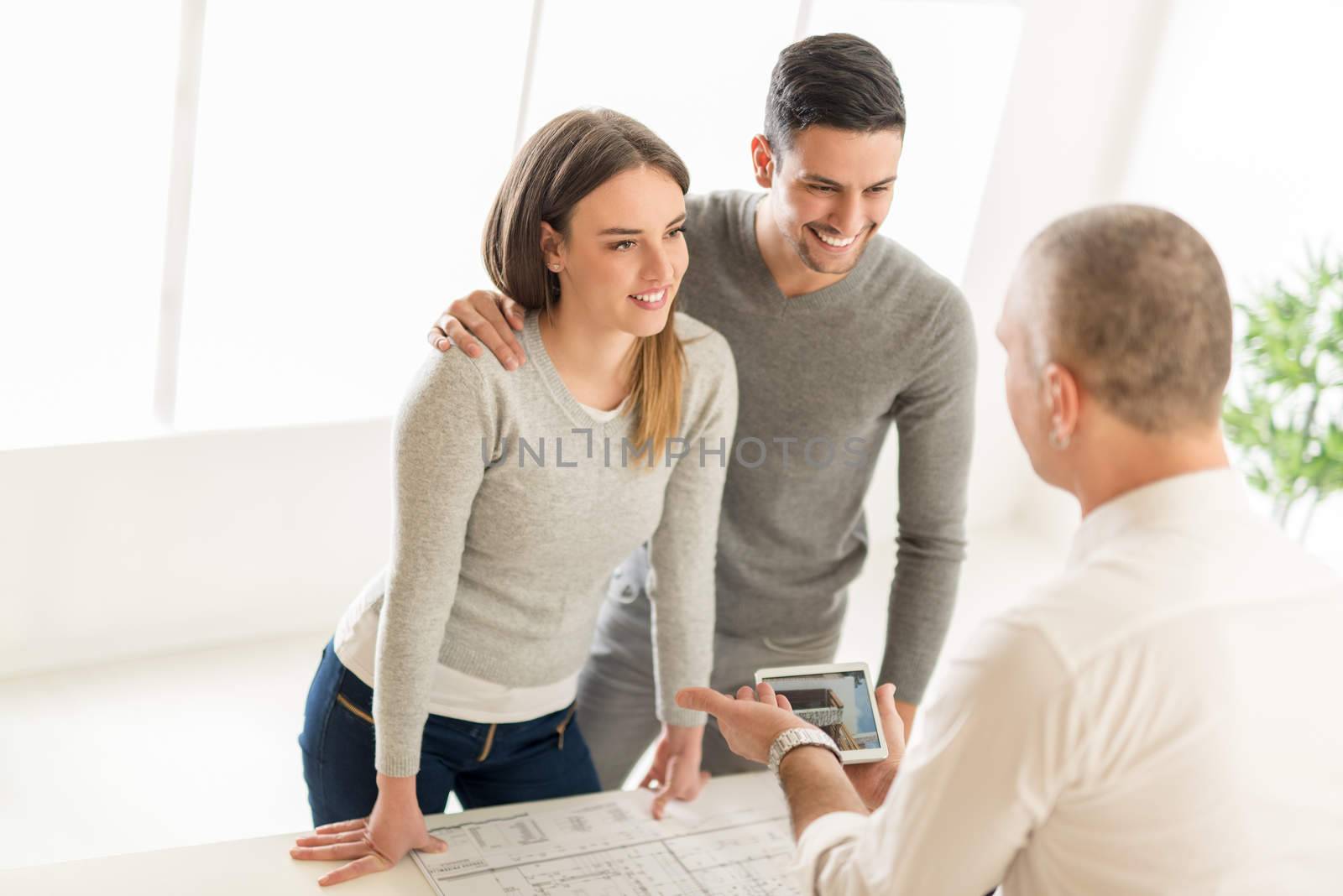 Young Couple consult with real estate agent about buying new house