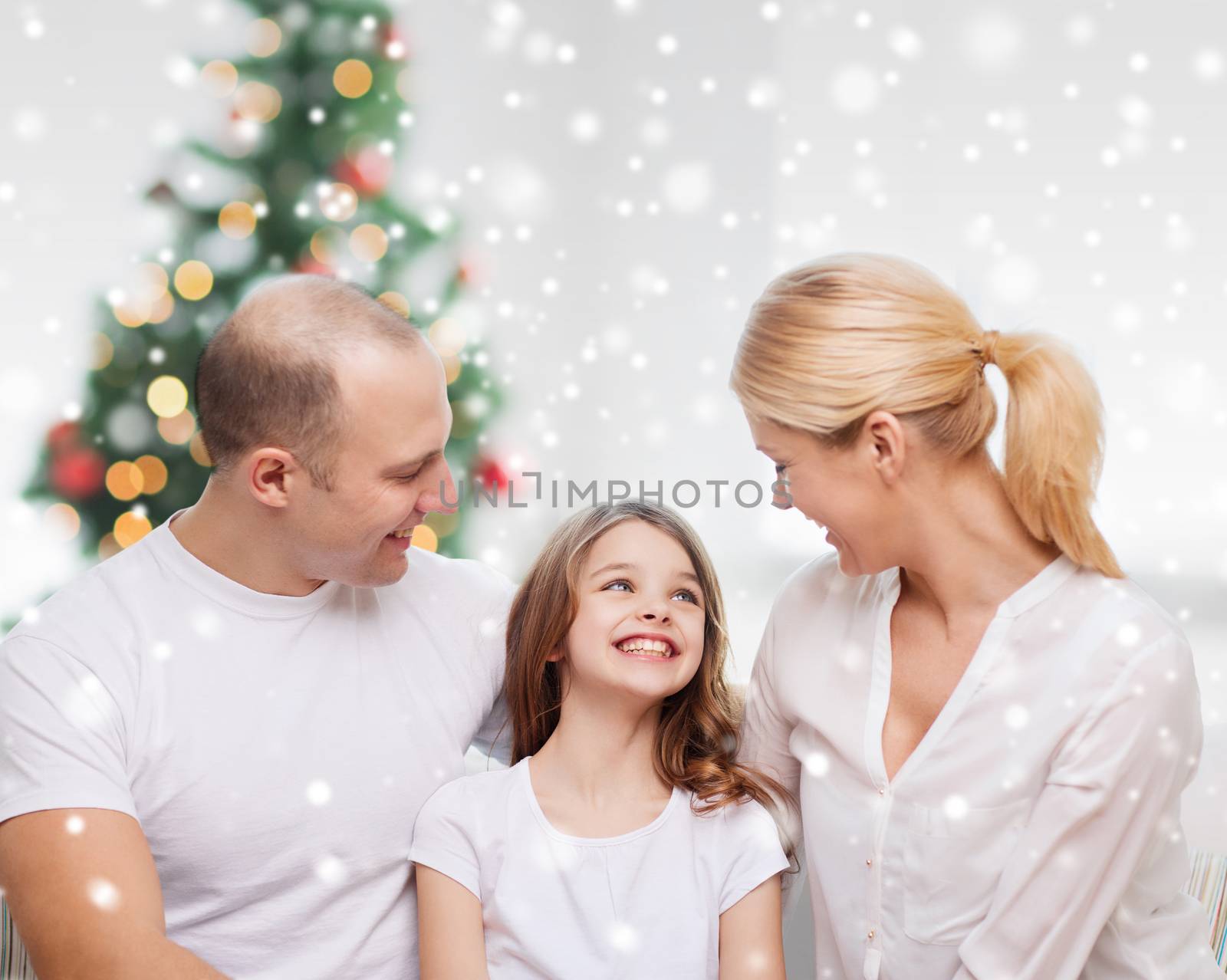 family, childhood, holidays and people - smiling mother, father and little girl over living room and christmas tree background