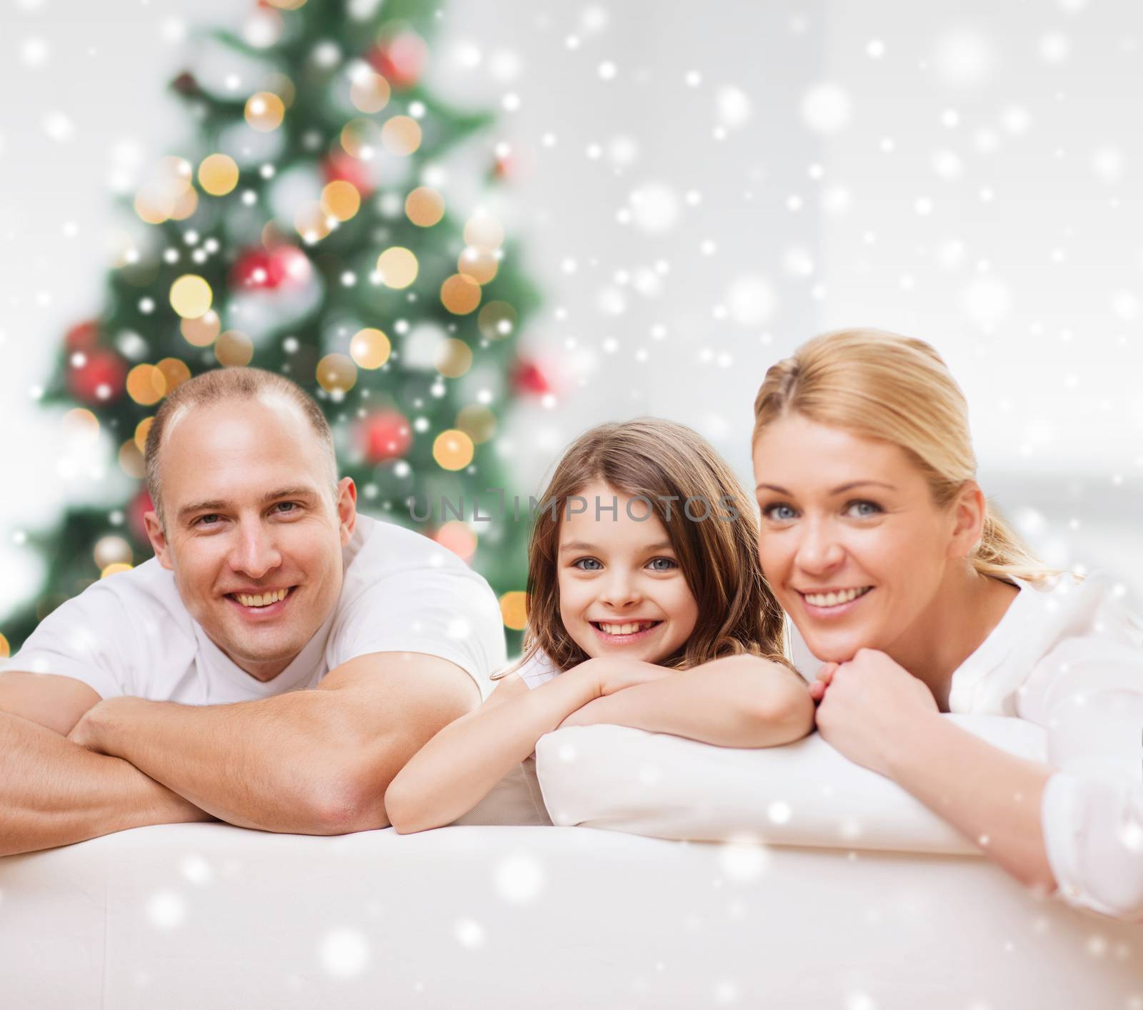 family, childhood, holidays and people - smiling mother, father and little girl over living room and christmas tree background