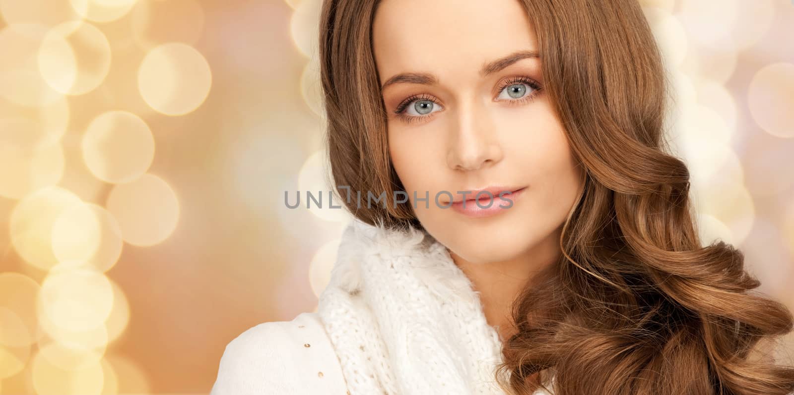 happiness, winter holidays, christmas and people concept - close up of smiling young woman in white warm clothes over beige lights background