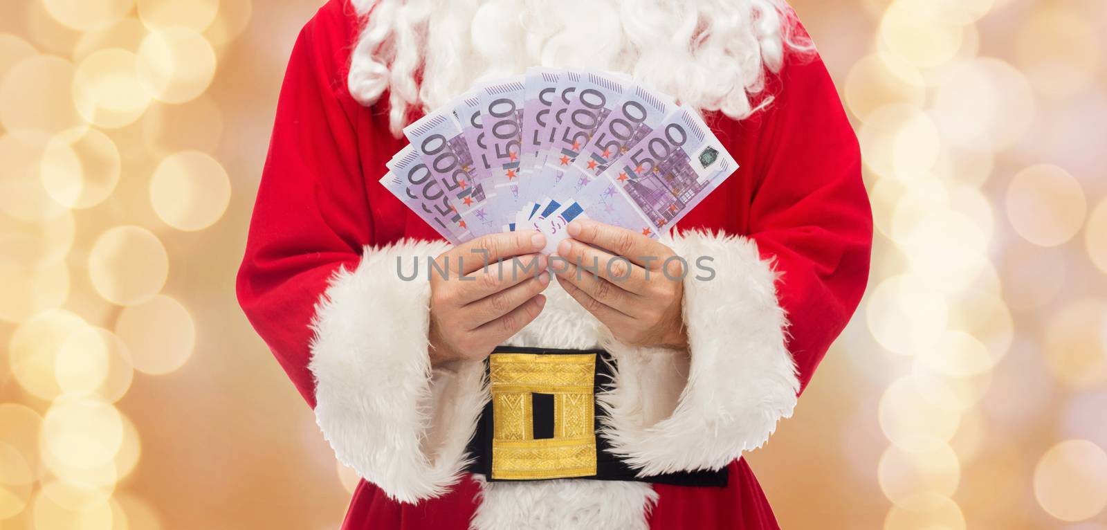 christmas, holidays, winning, currency and people concept - close up of santa claus with euro money over beige lights background