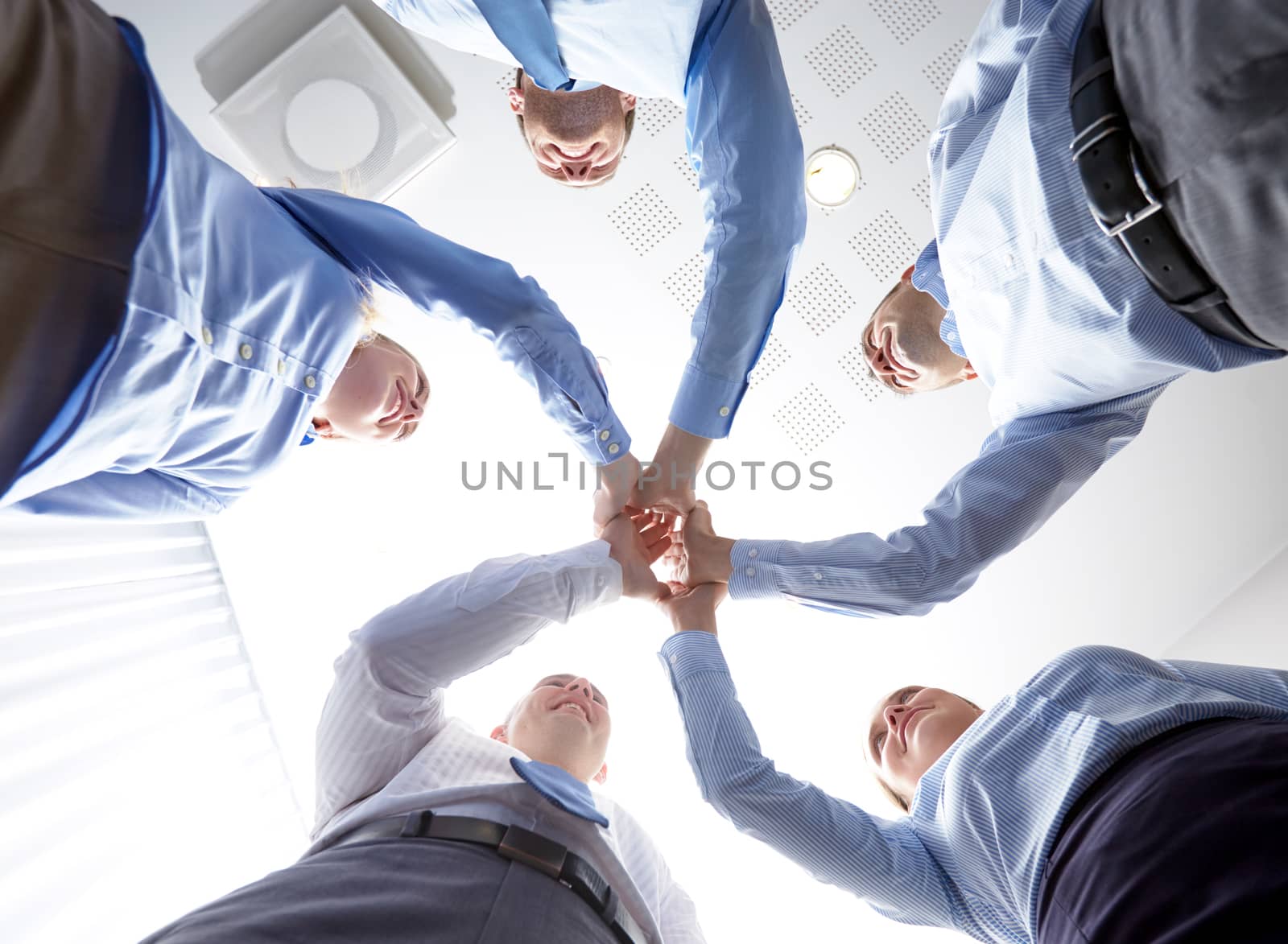 smiling group of businesspeople standing in circle by dolgachov