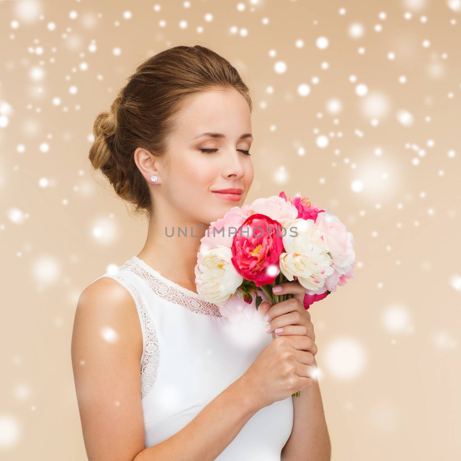 happiness, wedding, holidays and celebration concept - smiling bride or bridesmaid in white dress with bouquet of flowers over beige background and snow