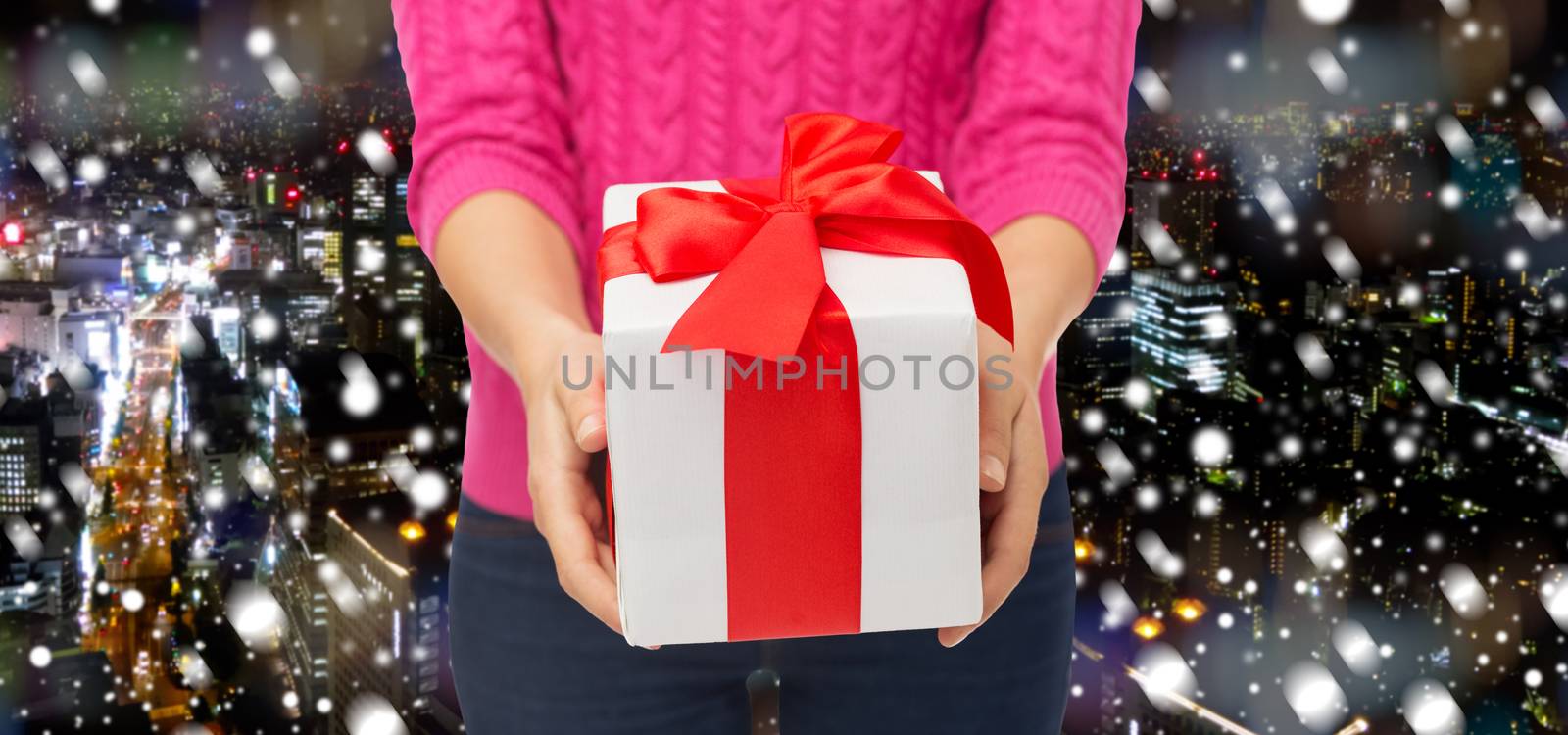 close up of woman in pink sweater holding gift box by dolgachov