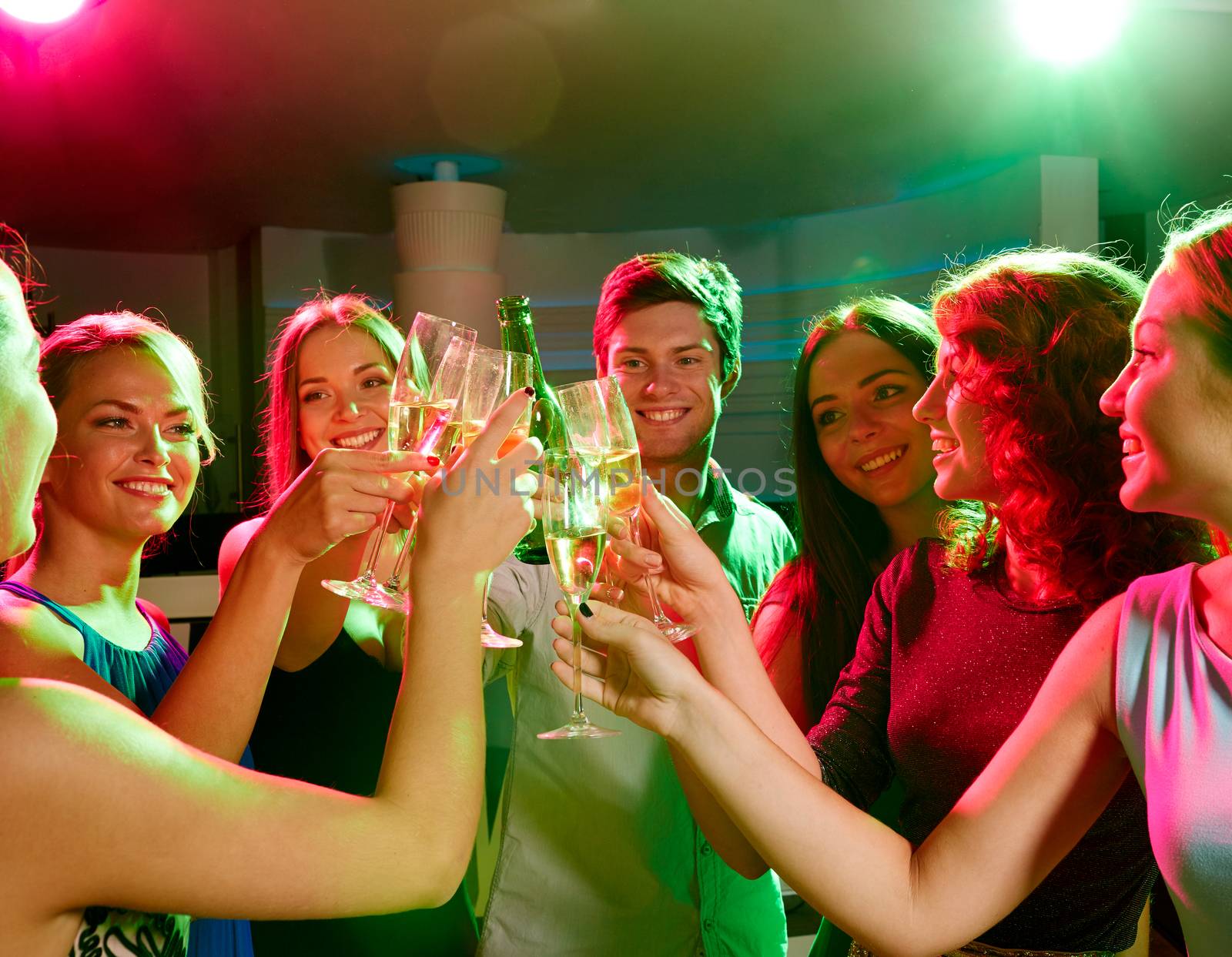 party, holidays, celebration, nightlife and people concept - smiling friends clinking glasses of champagne and beer in club