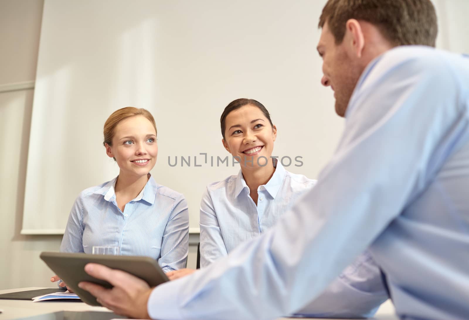 business, people, technology and teamwork concept - smiling businessman and businesswomen with tablet pc computer meeting in office