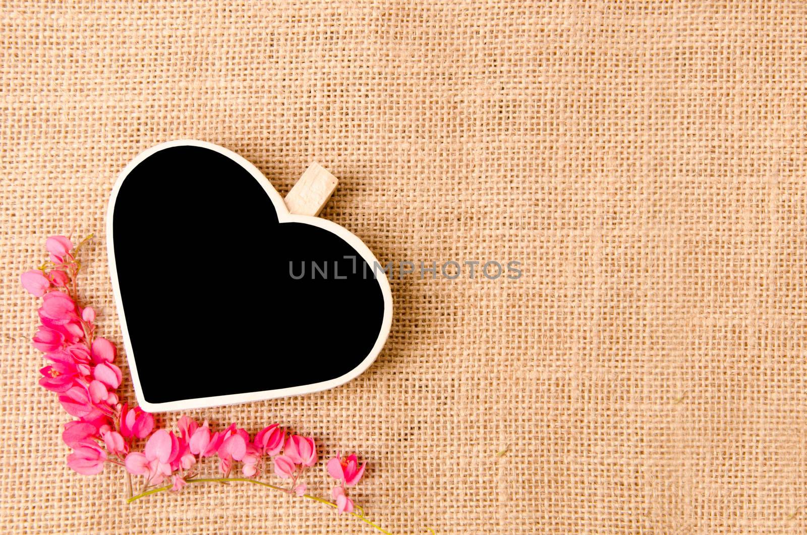 Black wood clip heart shape and flower on sack background