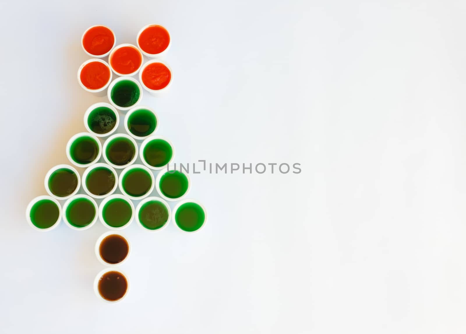 a tree made of glasses filled with colourful liquid reminiscent  a christmas tree