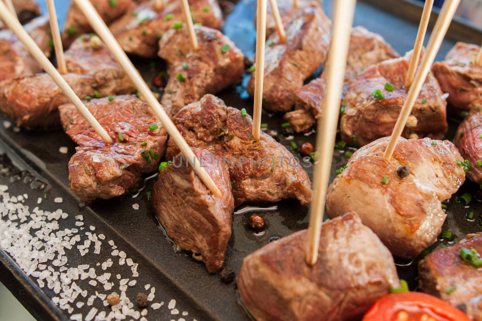 grilled barbecue meat on sticks served with vegetables