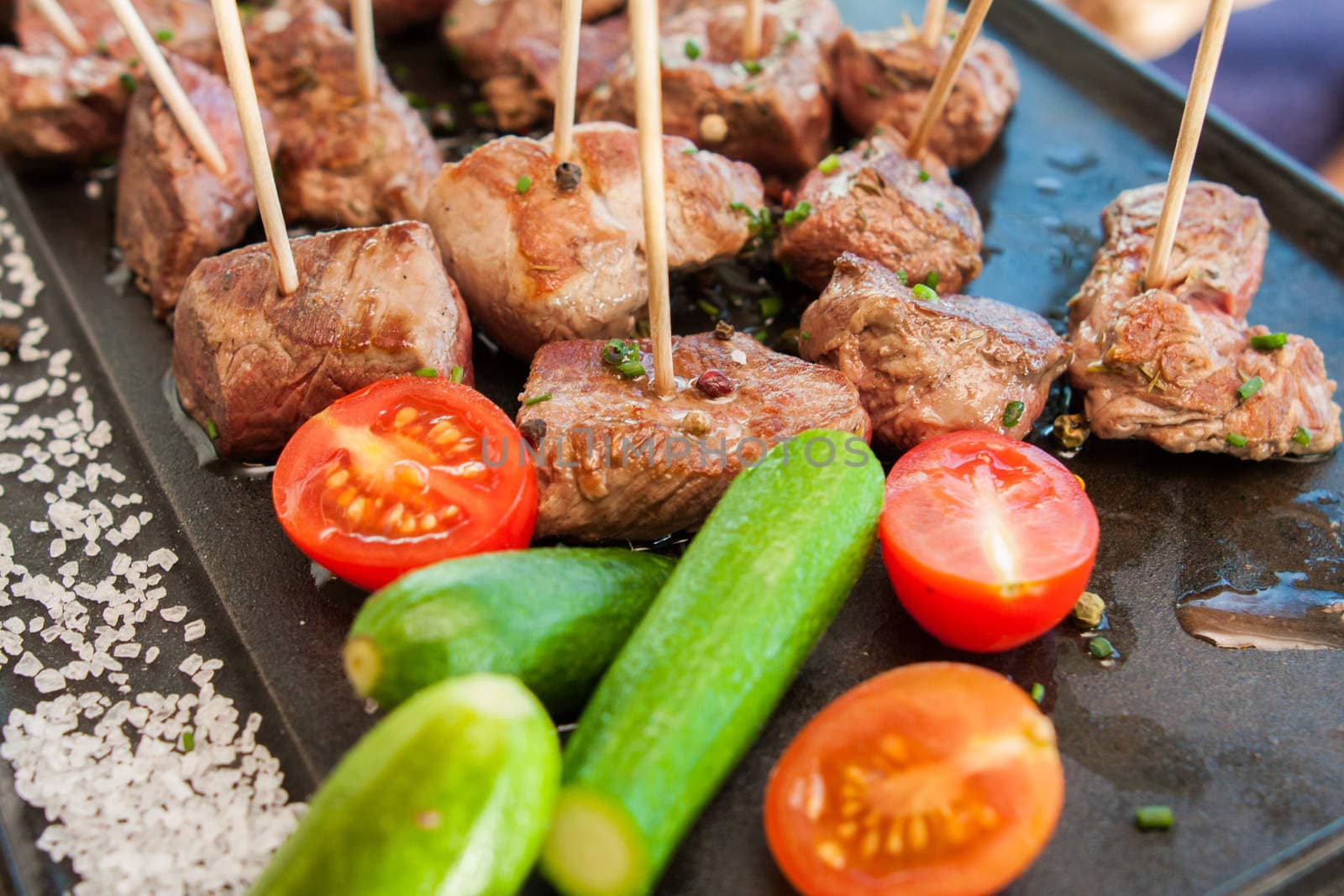 grilled barbecue meat on sticks served with vegetables