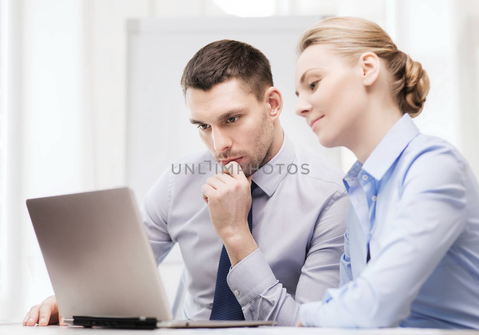 serious business couple with laptop computer by dolgachov