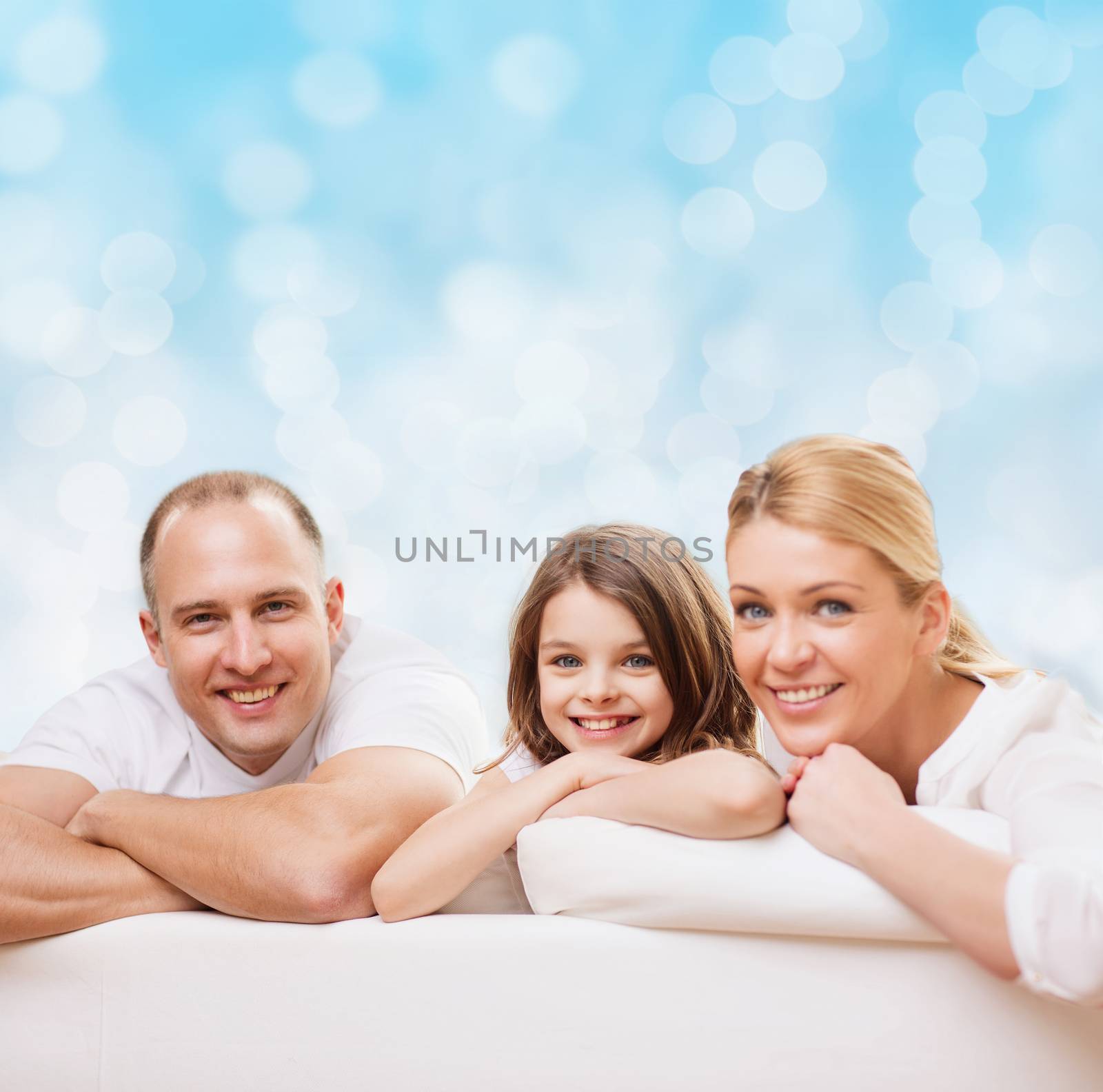 family, childhood, holidays and people - smiling mother, father and little girl over blue lights background