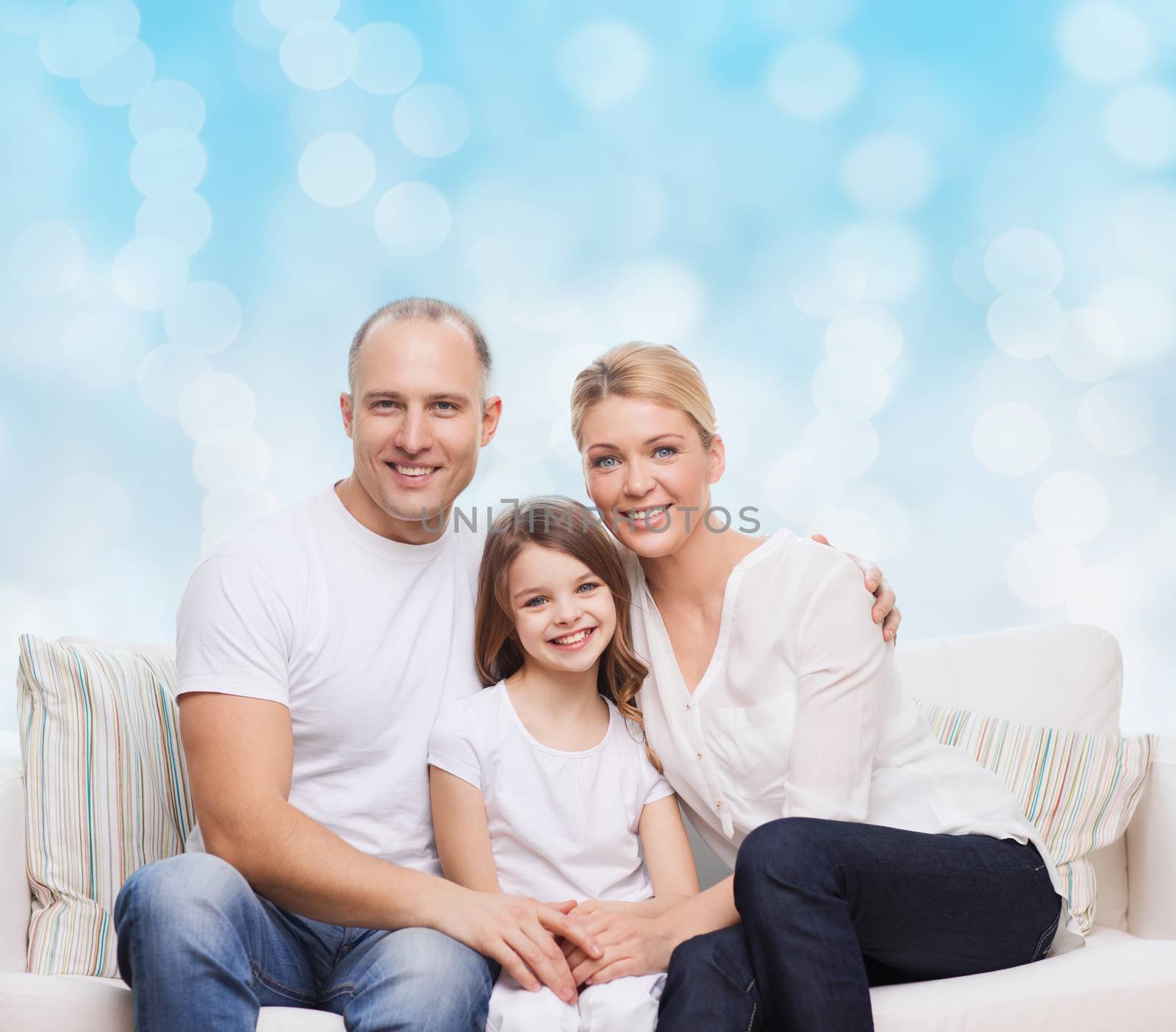 family, childhood, holidays and people concept - smiling mother, father and little girl over blue lights background