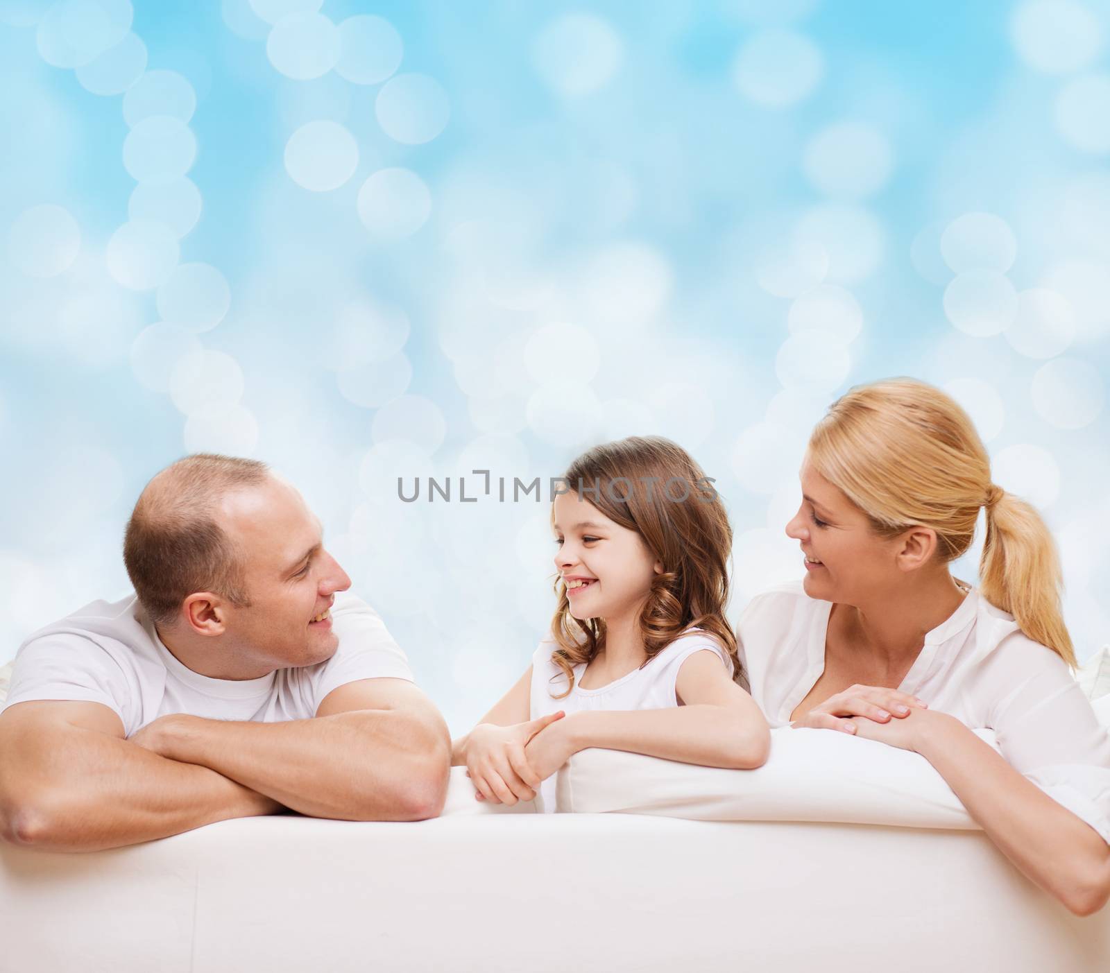 family, childhood, holidays and people - smiling mother, father and little girl over blue lights background