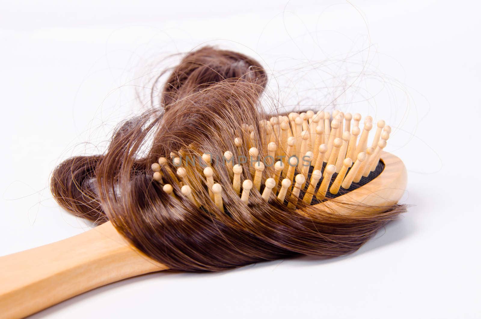 wooden comb brush with hair, on white background