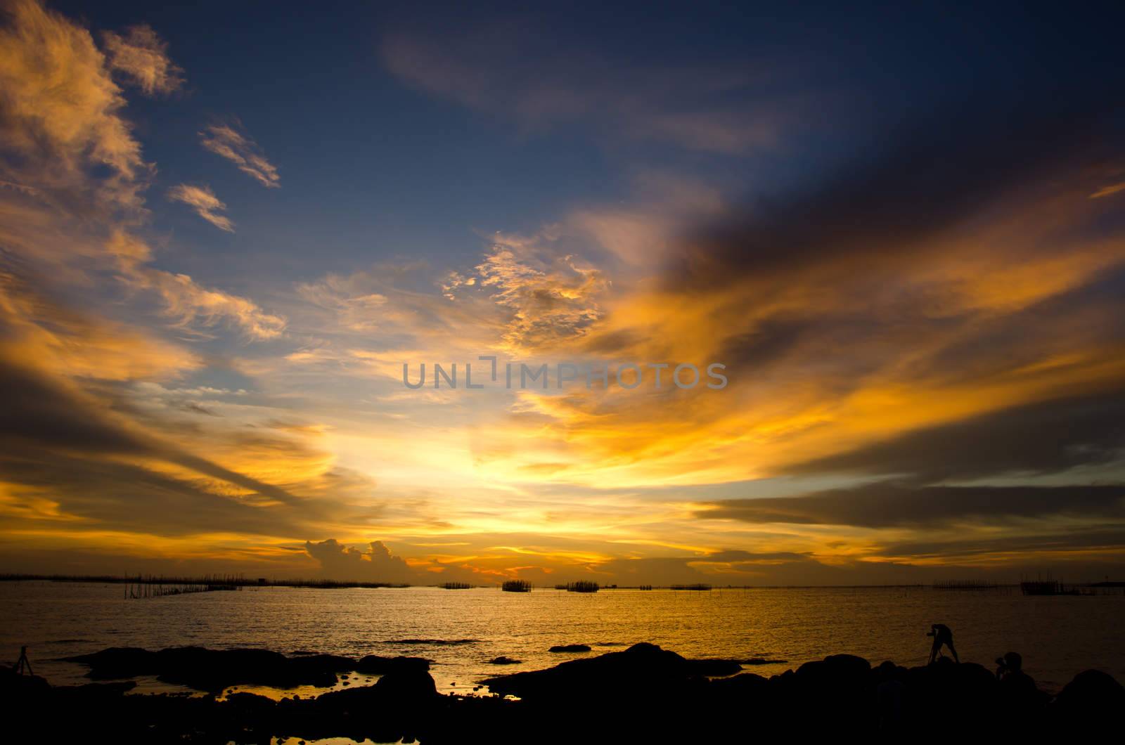 sunset on the beach with beautiful sky and Silhouette of young photographer