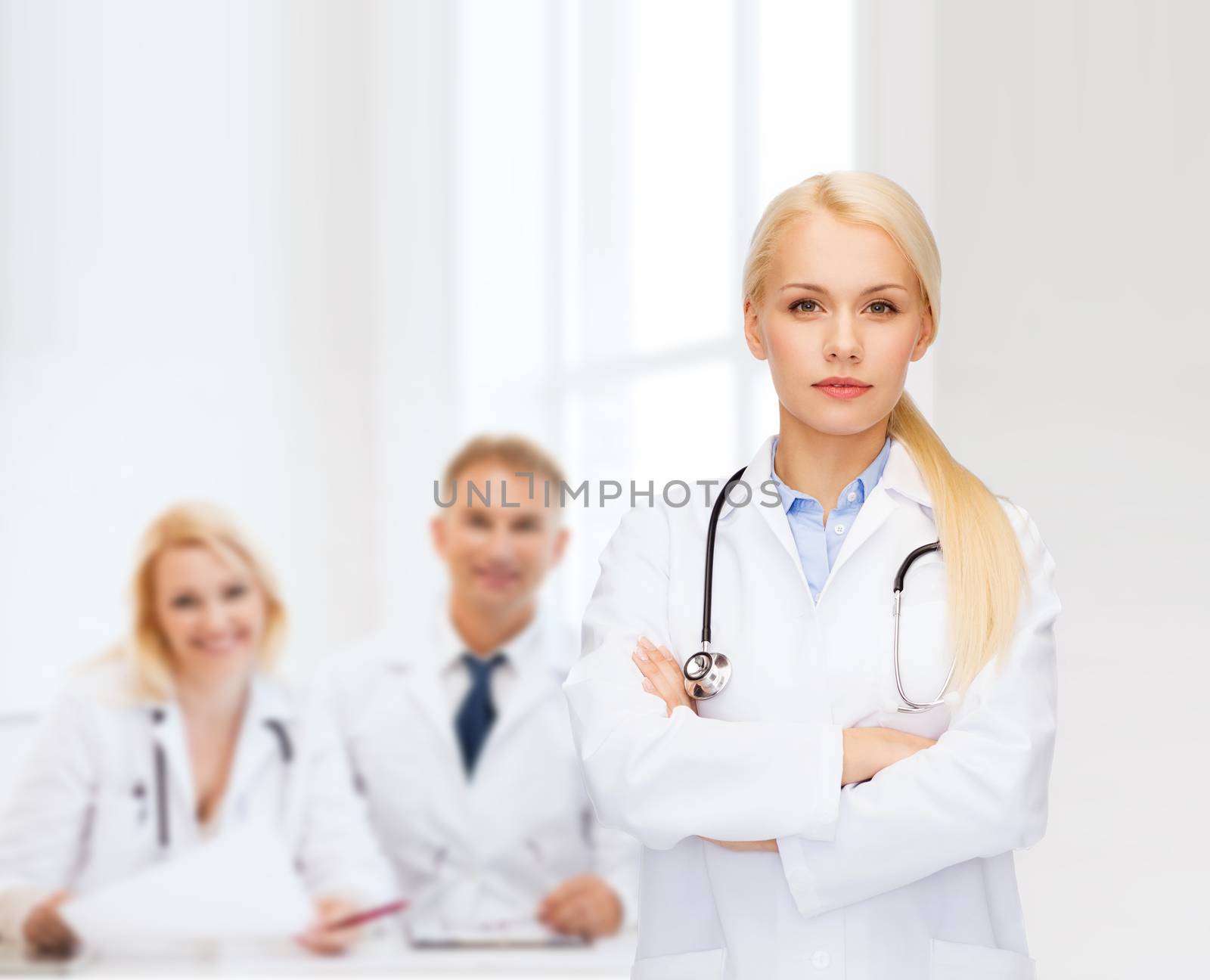 serious female doctor with stethoscope by dolgachov