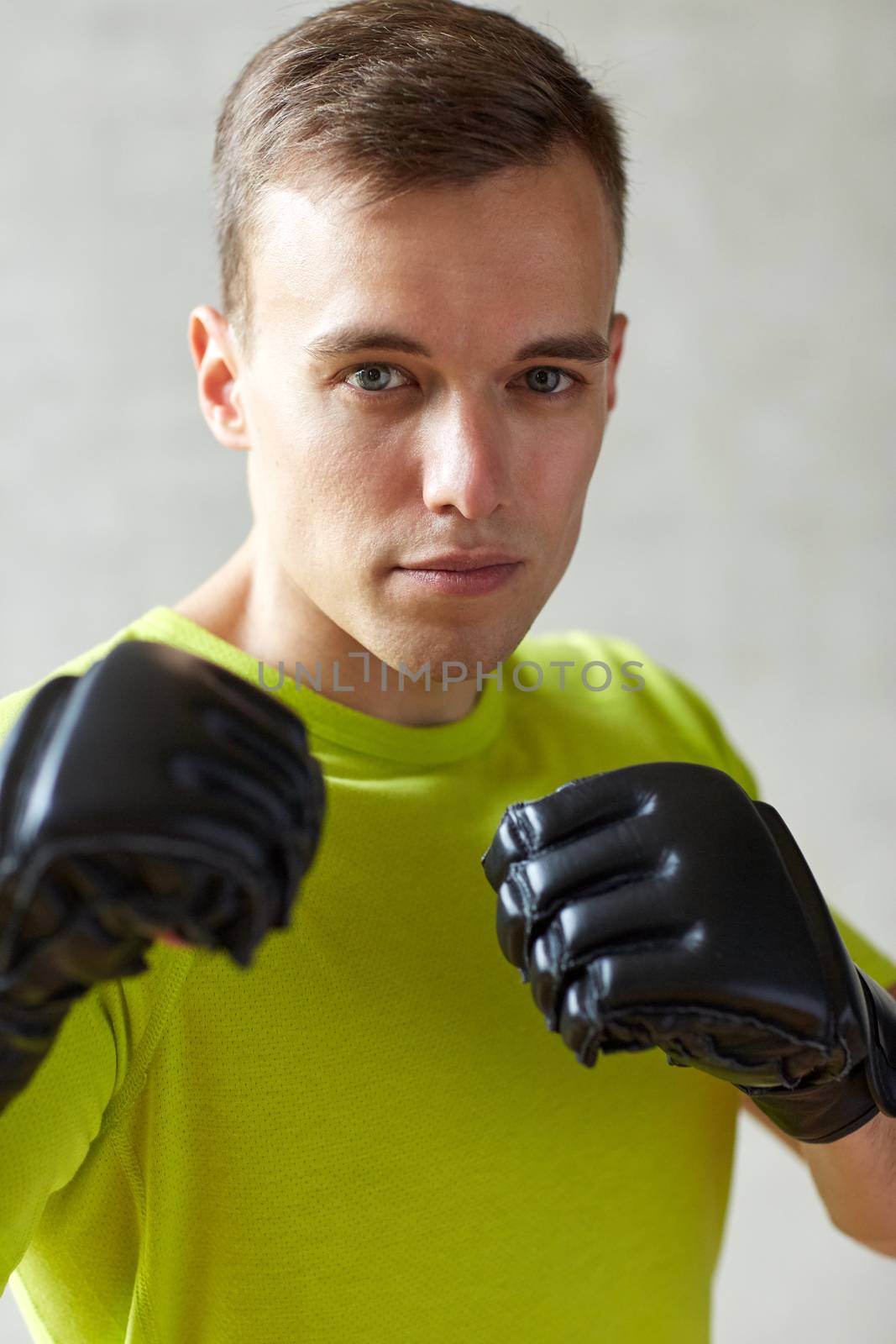 sport, box and people concept - young man with gloves boxing in gym