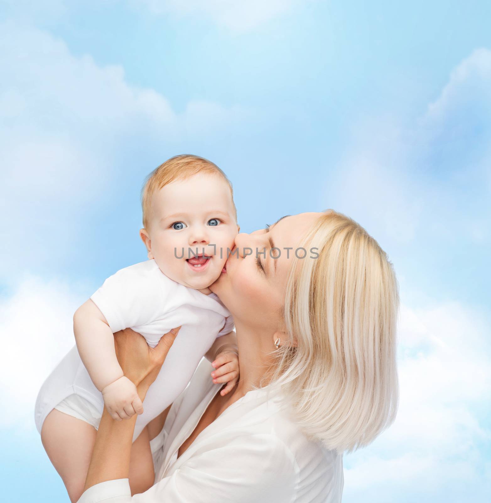happy mother kissing smiling baby by dolgachov