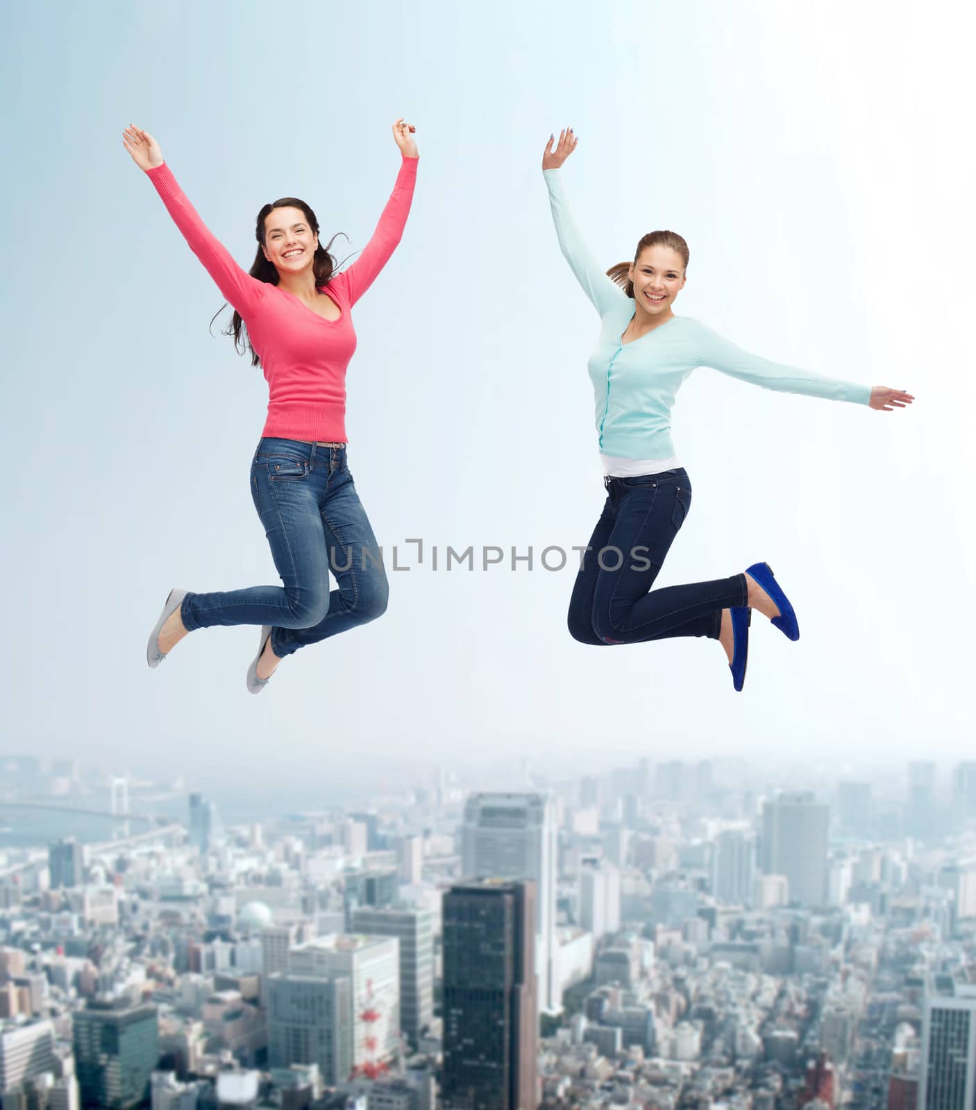 smiling young women jumping in air by dolgachov