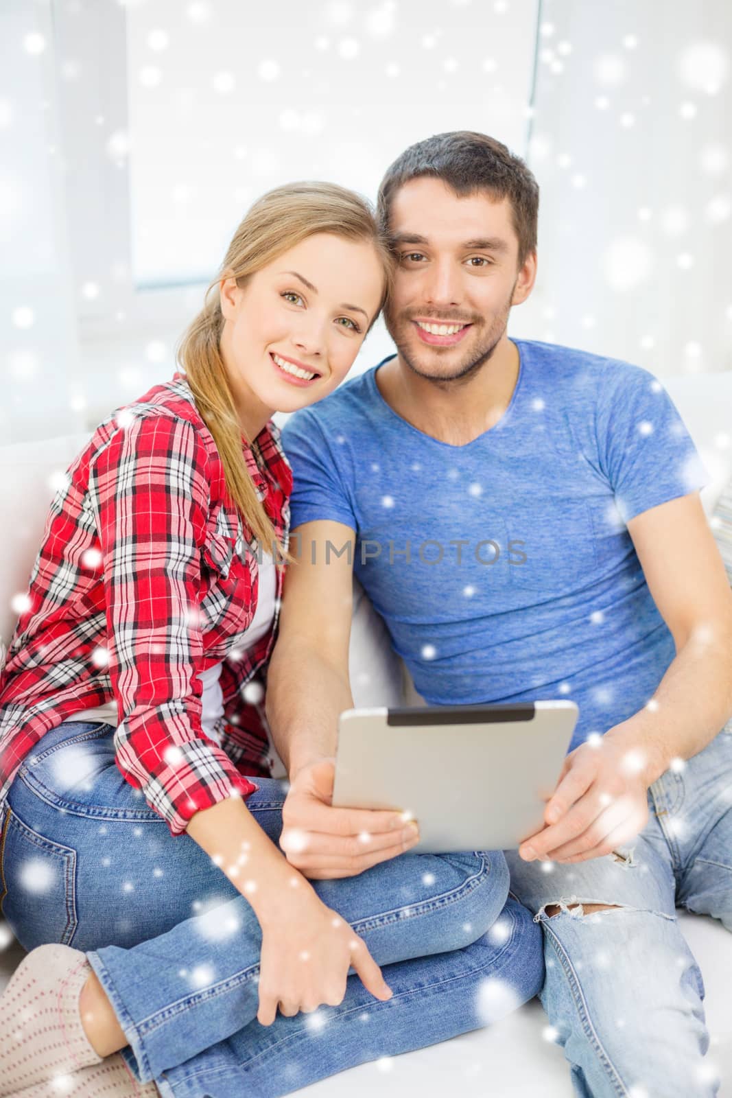technology, people and relationships concept - smiling couple with laptop computer sitting on sofa at home
