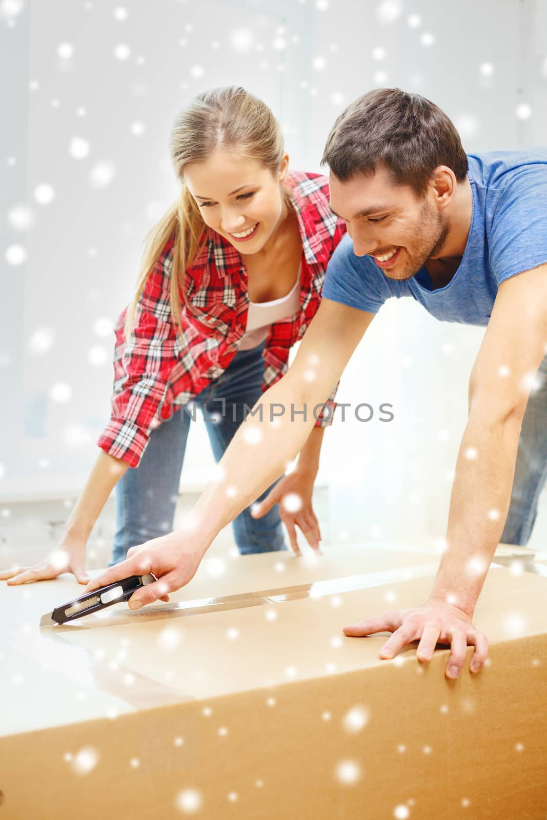 repair, moving in and people concept - smiling couple opening big cardboard box with cutter at home