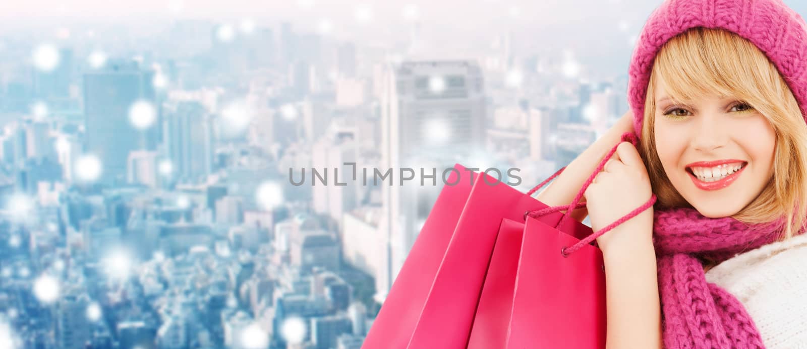 smiling young woman with shopping bags by dolgachov