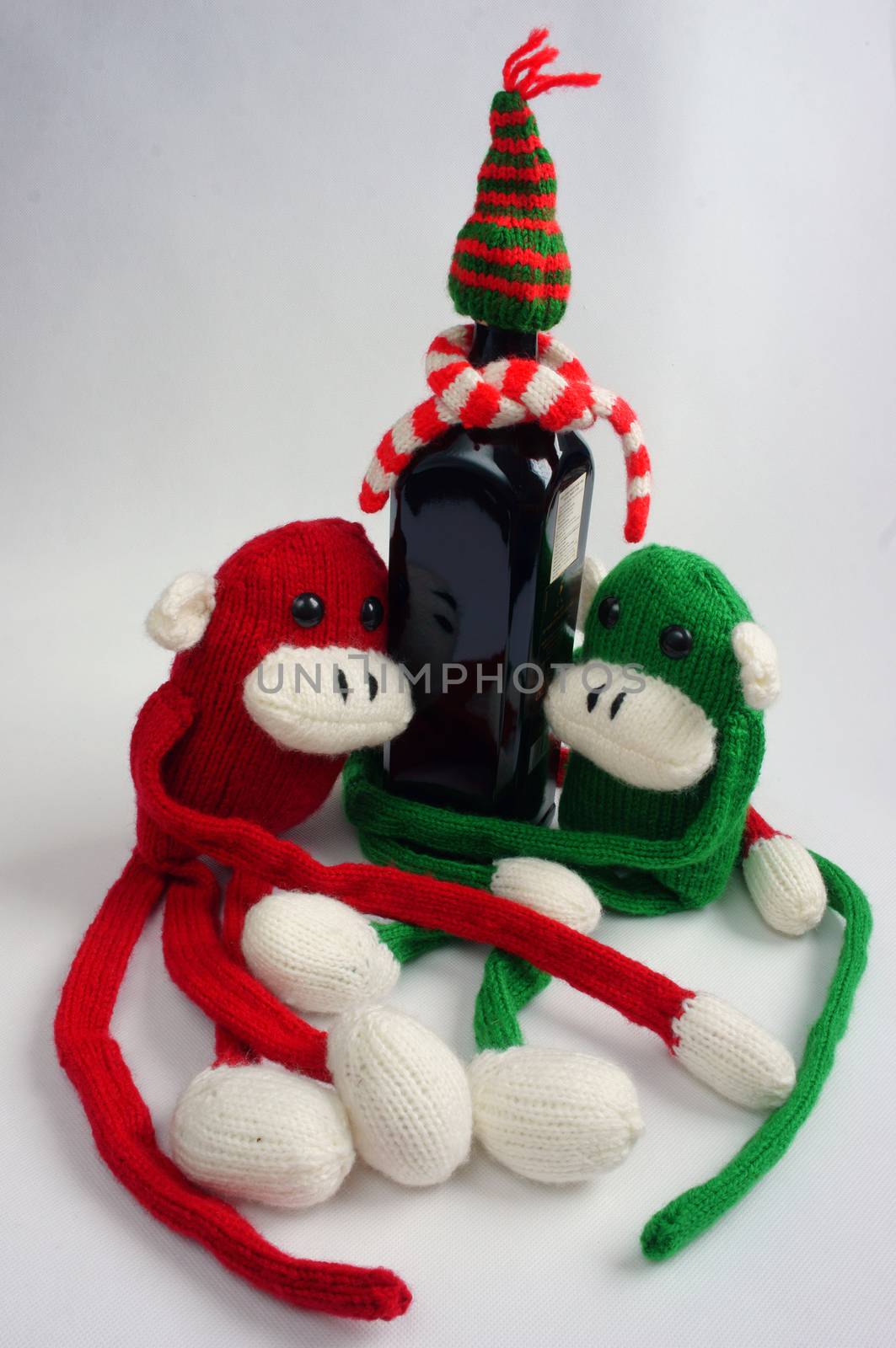 Funny Christmas background, two knitted monkey hold noel wine bottle, Xmas alphabet in red and green yarn, symbol to merry christmas and happy new year, a year of monkeys