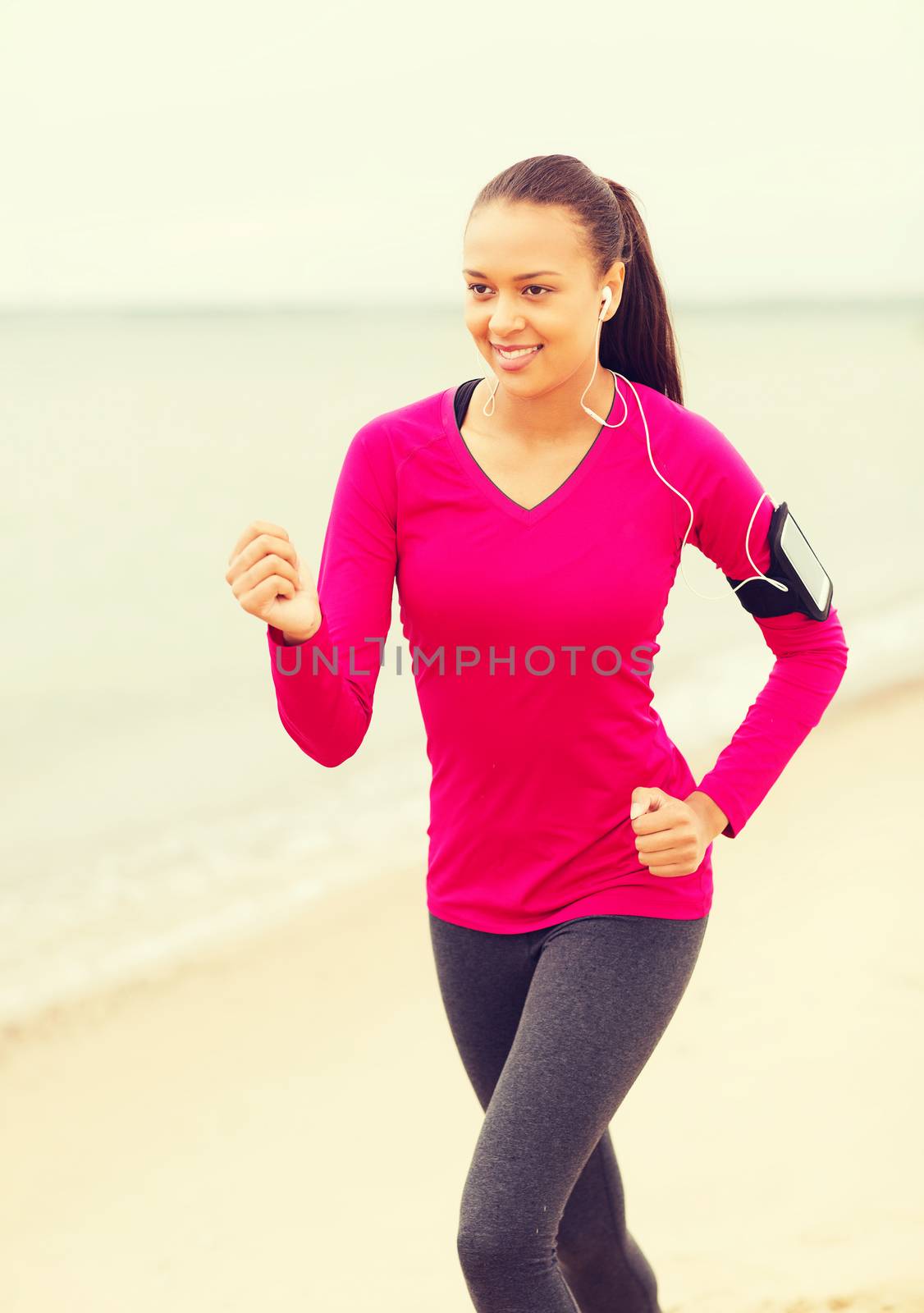 smiling young woman running outdoors by dolgachov