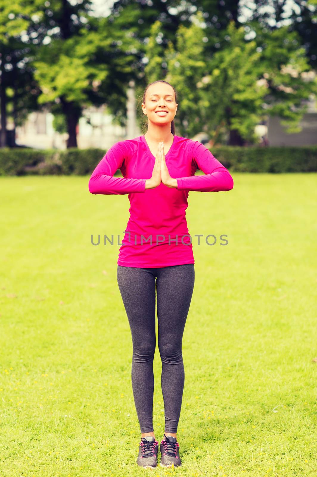 sport, exercise, park and lifestyle concept - smiling african american woman exercising outdoors