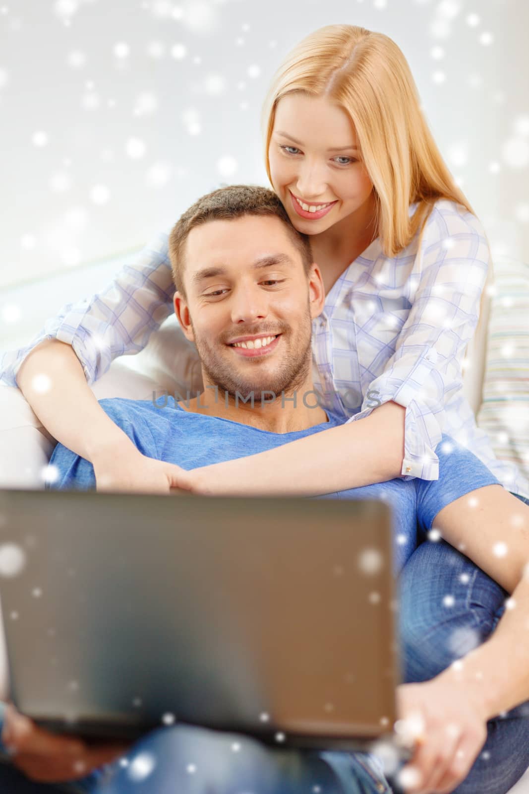 smiling happy couple with laptop at home by dolgachov