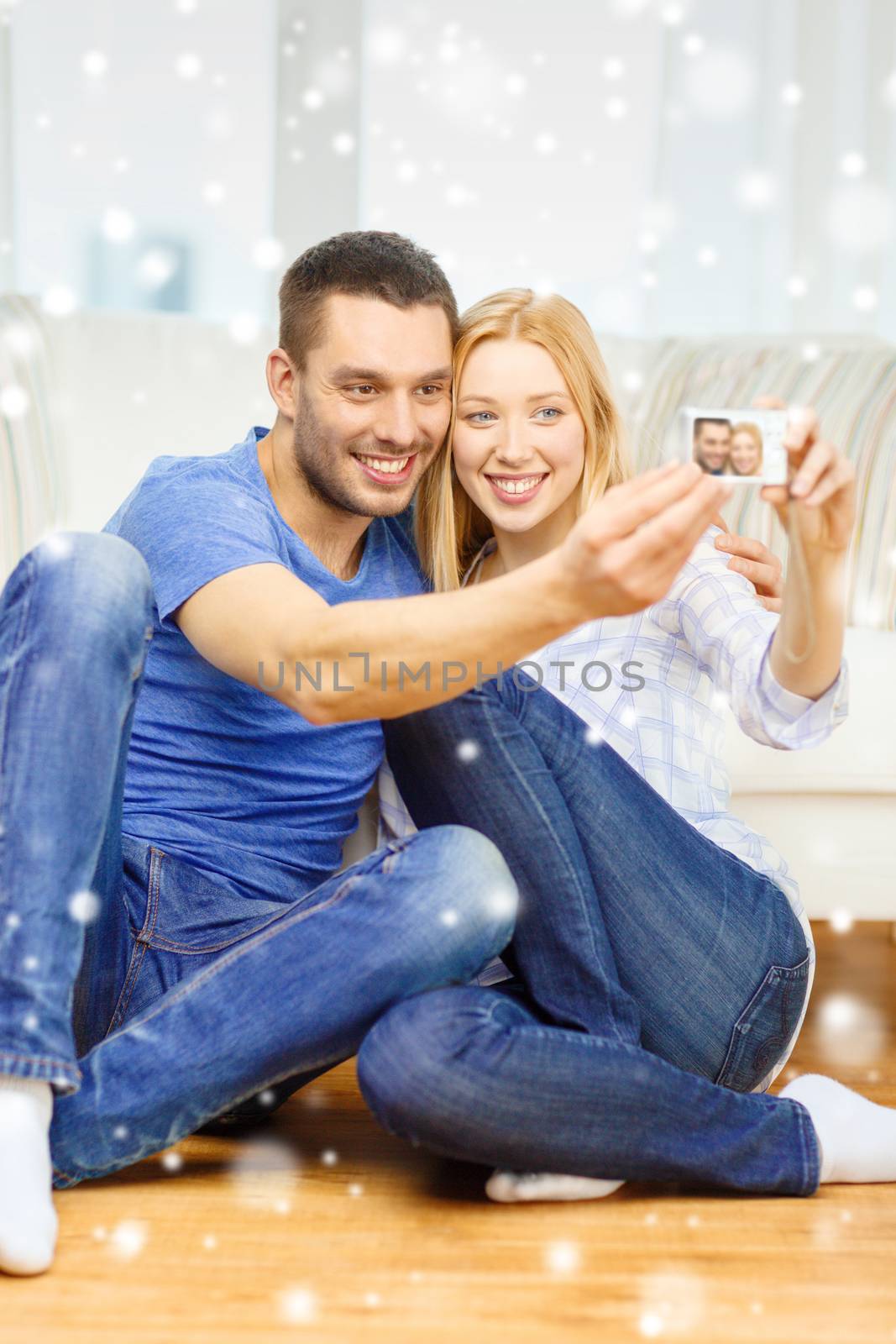 smiling couple taking picture with digital camera by dolgachov