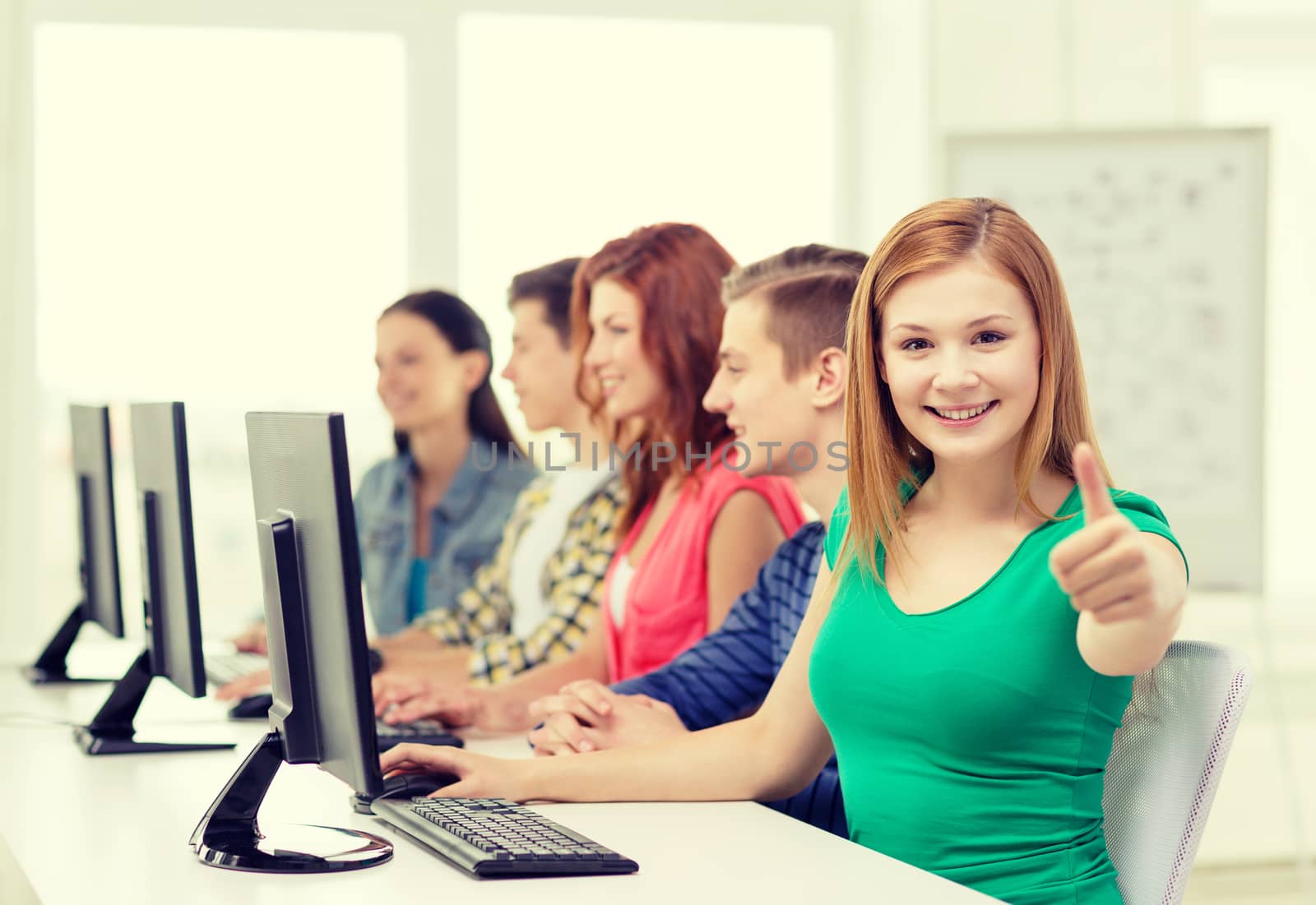 female student with classmates in computer class by dolgachov