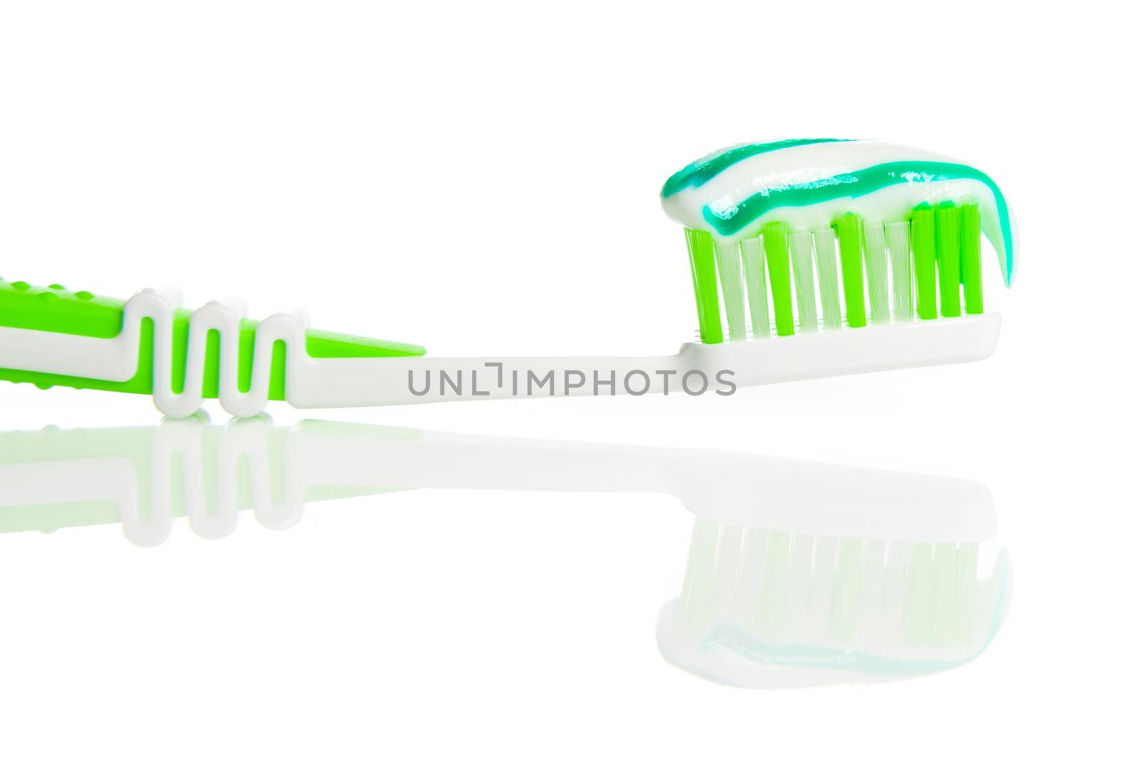 Toothbrush and toothpaste on white background by motorolka