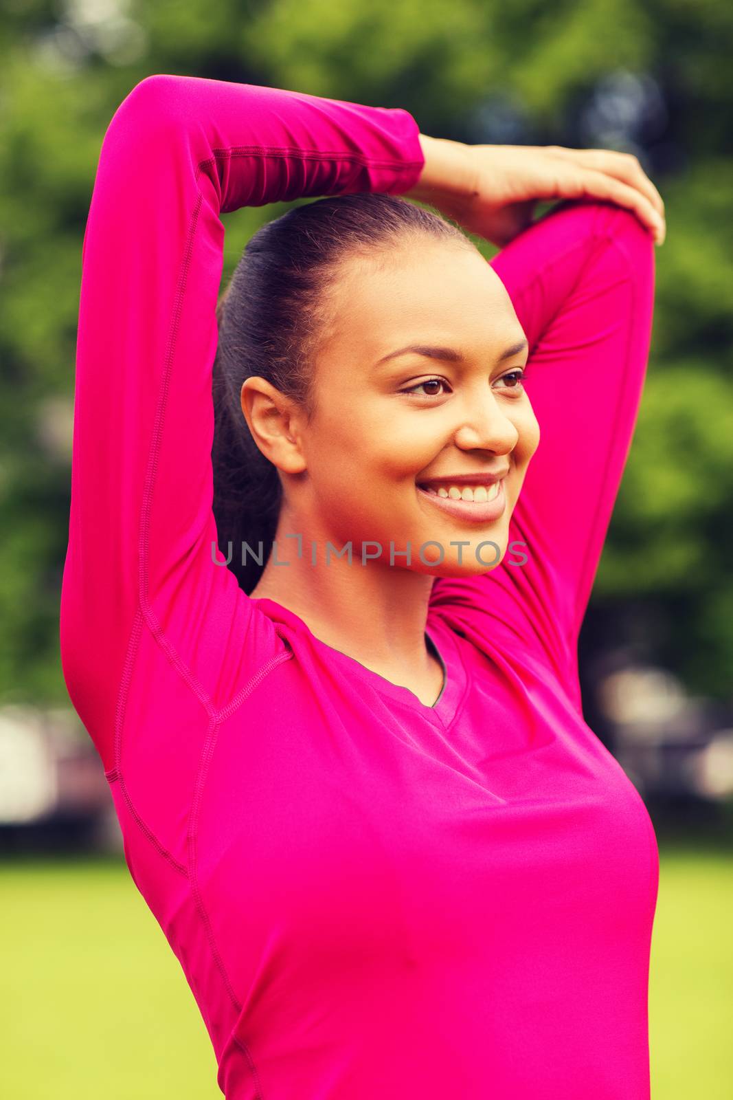 smiling black woman stretching leg outdoors by dolgachov